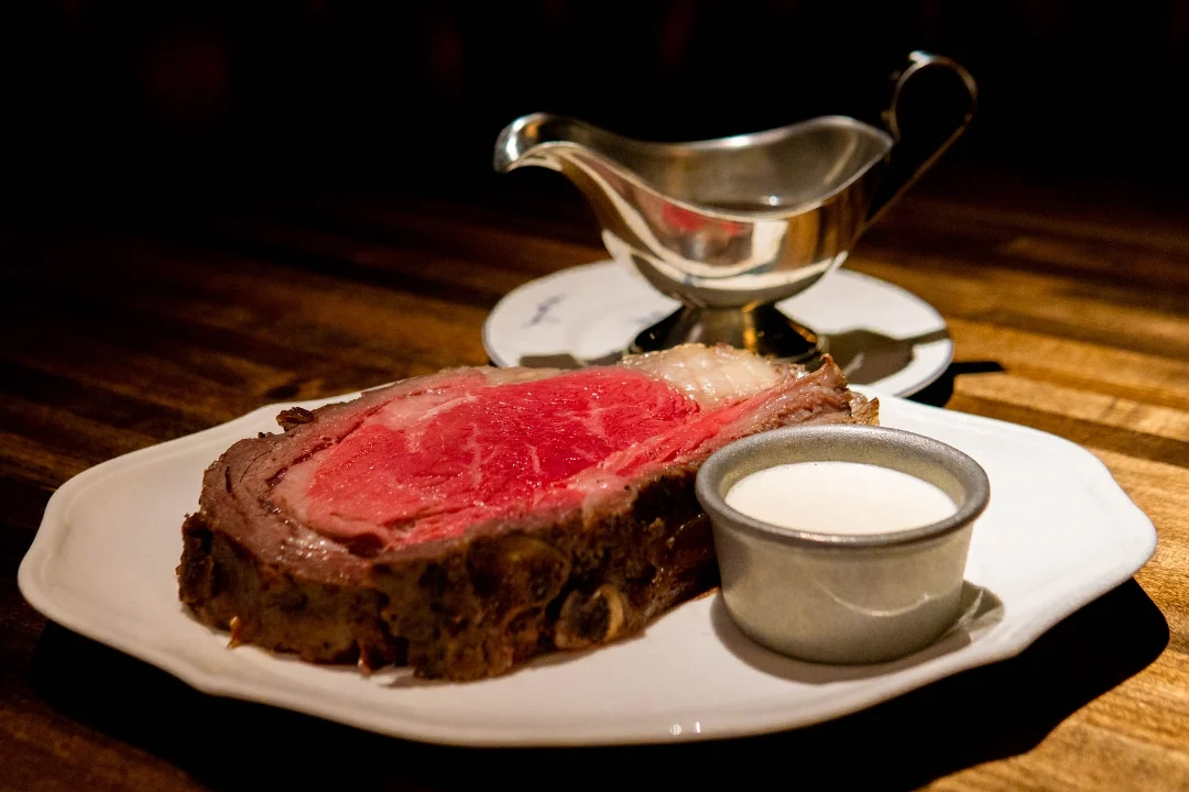 Prime rib on a plate with a side of sauce at 4 Charles Prime Rib, West Village.