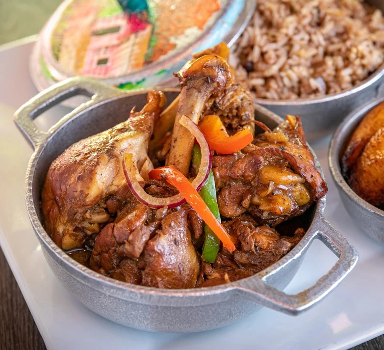 Close-up of a meat dish in a metal pot with rice and vegetables at Ajo y Orégano, Belmont.
