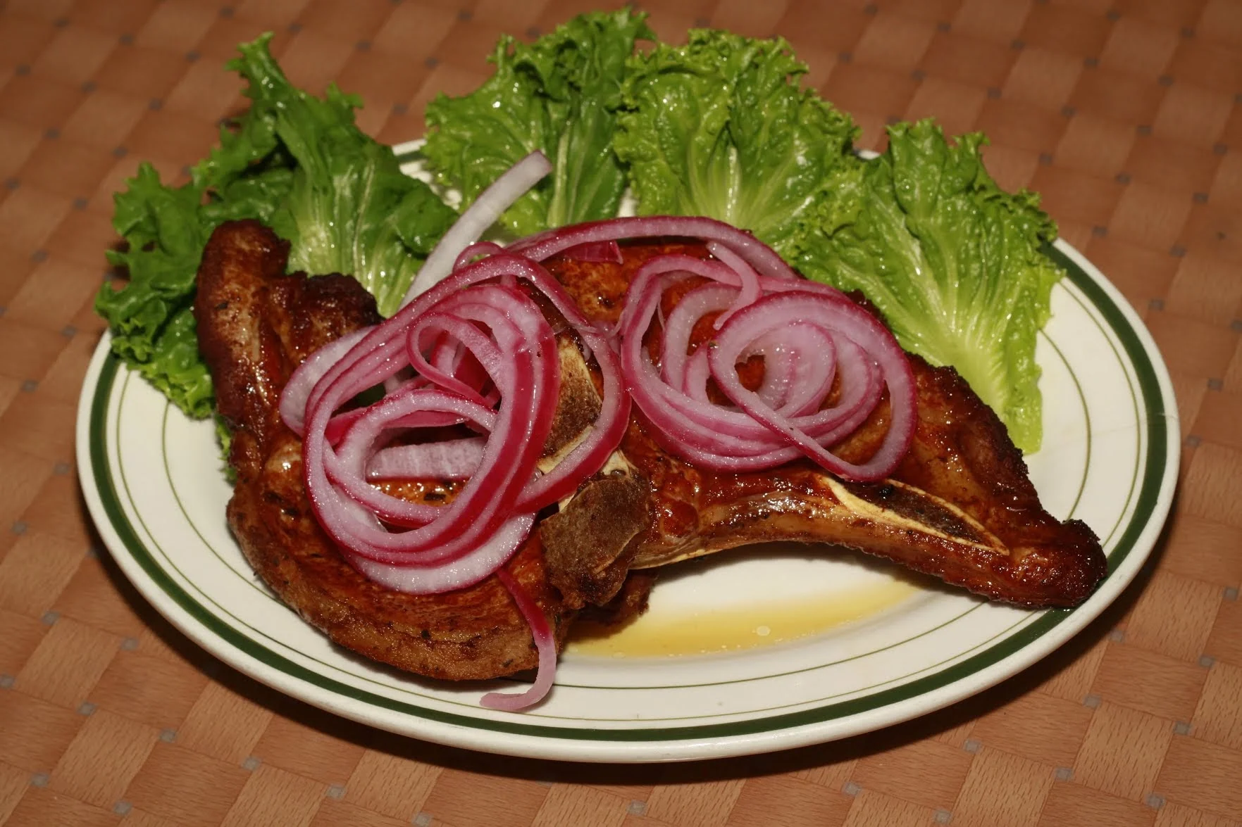 Plate with grilled meat topped with onions and lettuce at El Nuevo Pollo Sabroso 2, Parkchester.