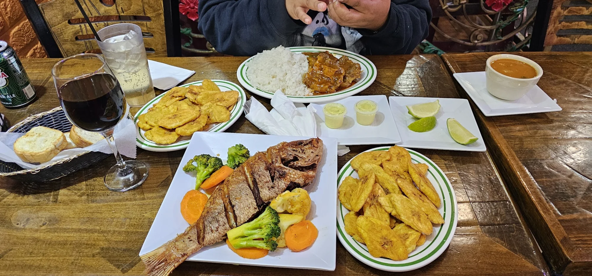 A table with various dishes including fish, broccoli, plantains, and rice at La Estrella, Fordham.