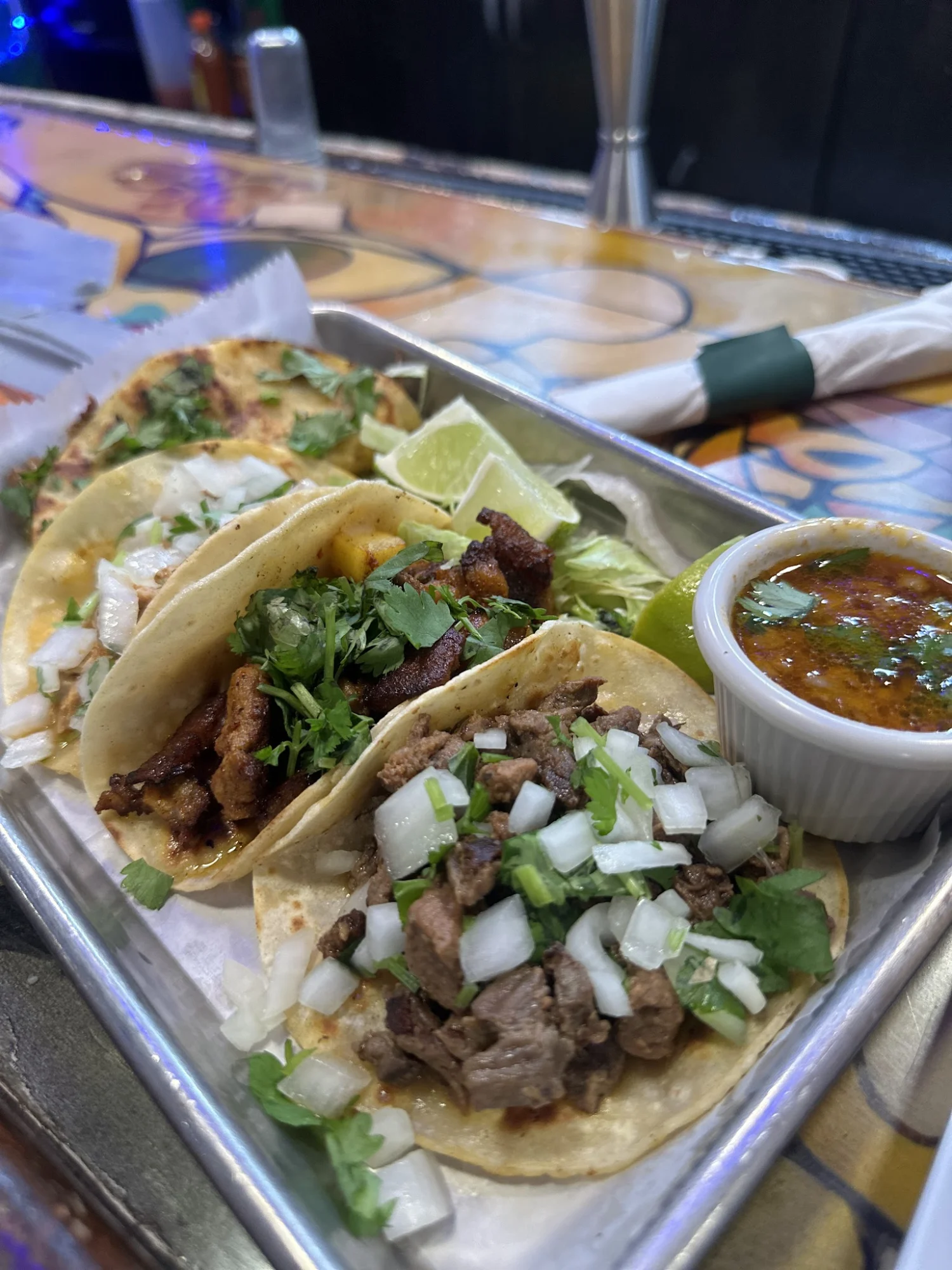 Tray with assorted tacos topped with onions and herbs at Pedro's bar and restaurant, Bronx NYC.