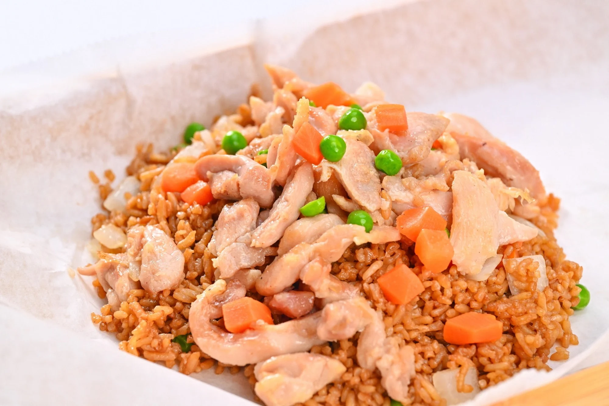 A1 Wings & Seafood in Bronx featured image Close-up of fried rice with chicken, peas, and carrots in a paper tray from A1 Wings & Seafood, Melrose, Bronx NYC.