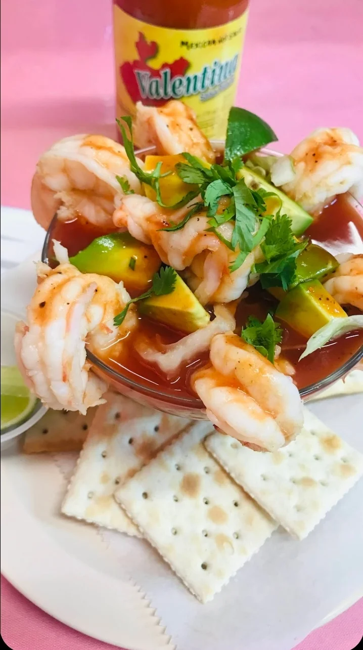 Shrimp cocktail with avocado, crackers, and lime on a pink tablecloth at La Perla Mexicana, Mott Haven.