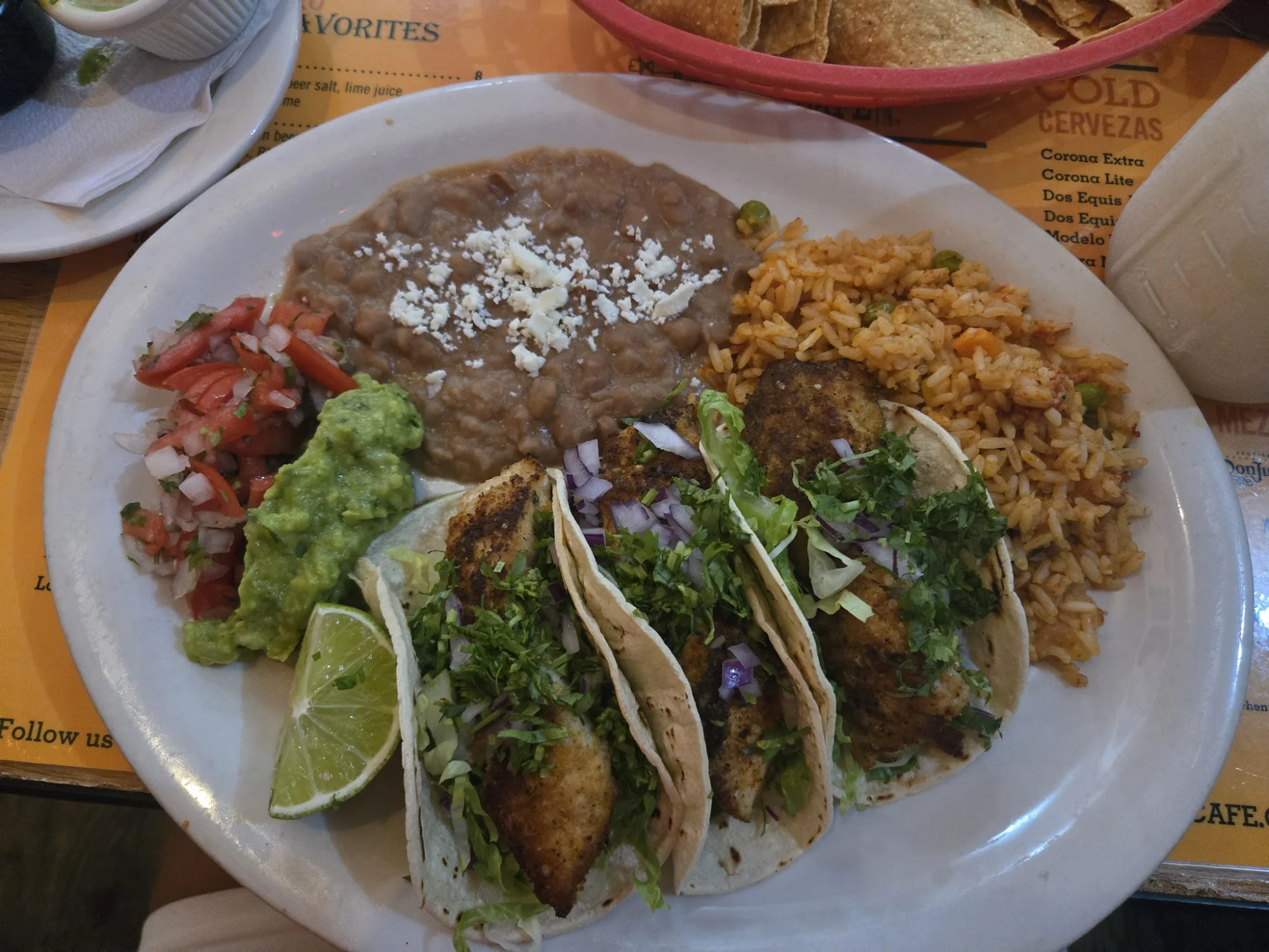 Plate with tacos, refried beans, rice, guacamole, and pico de gallo at 5 Burro Cafe, Forest Hills.
