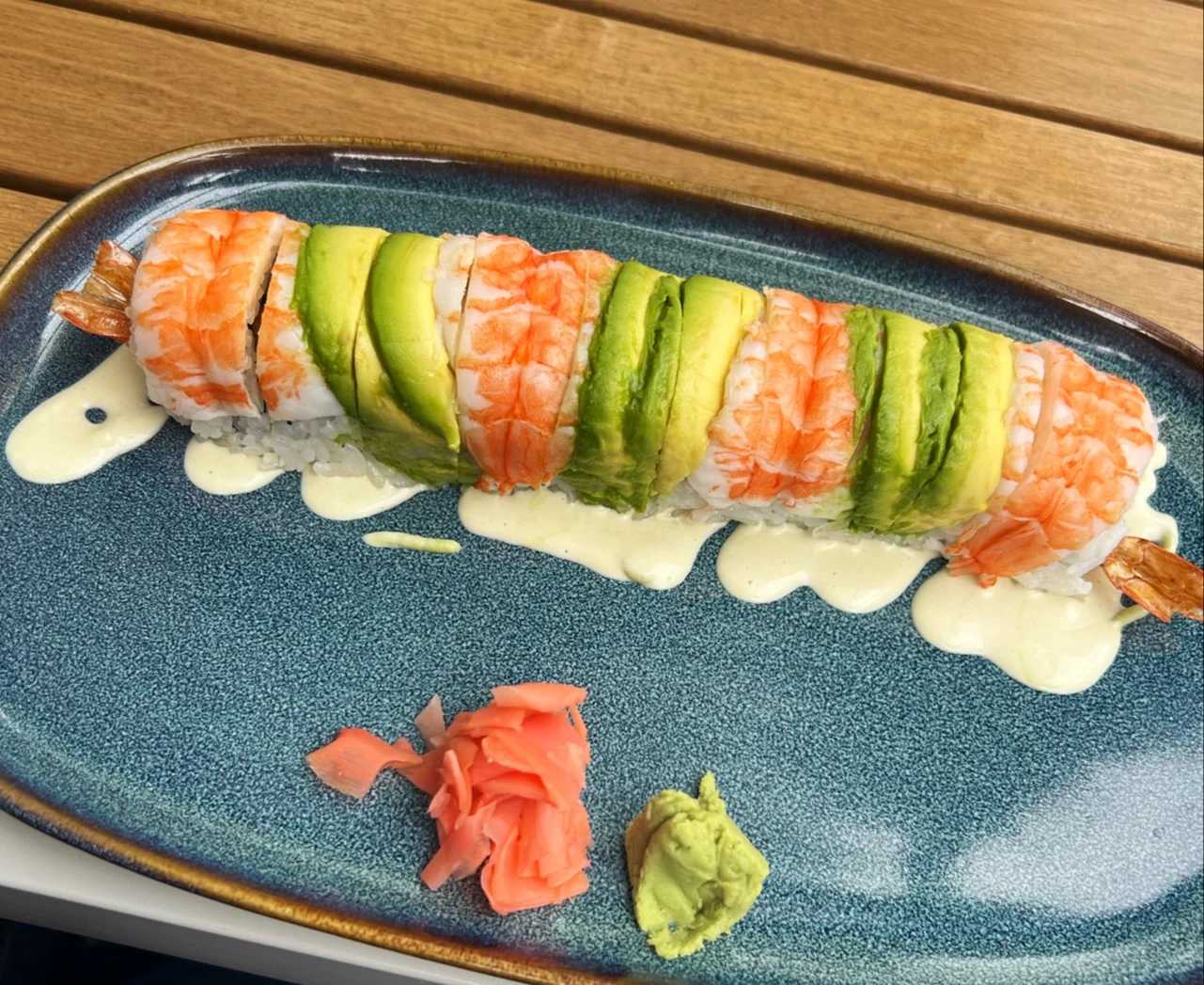 Minato Izakaya & Garden by Porto Salvo featured image Close-up of sushi roll with shrimp, avocado on a blue plate at Minato Izakaya & Garden, Concourse.