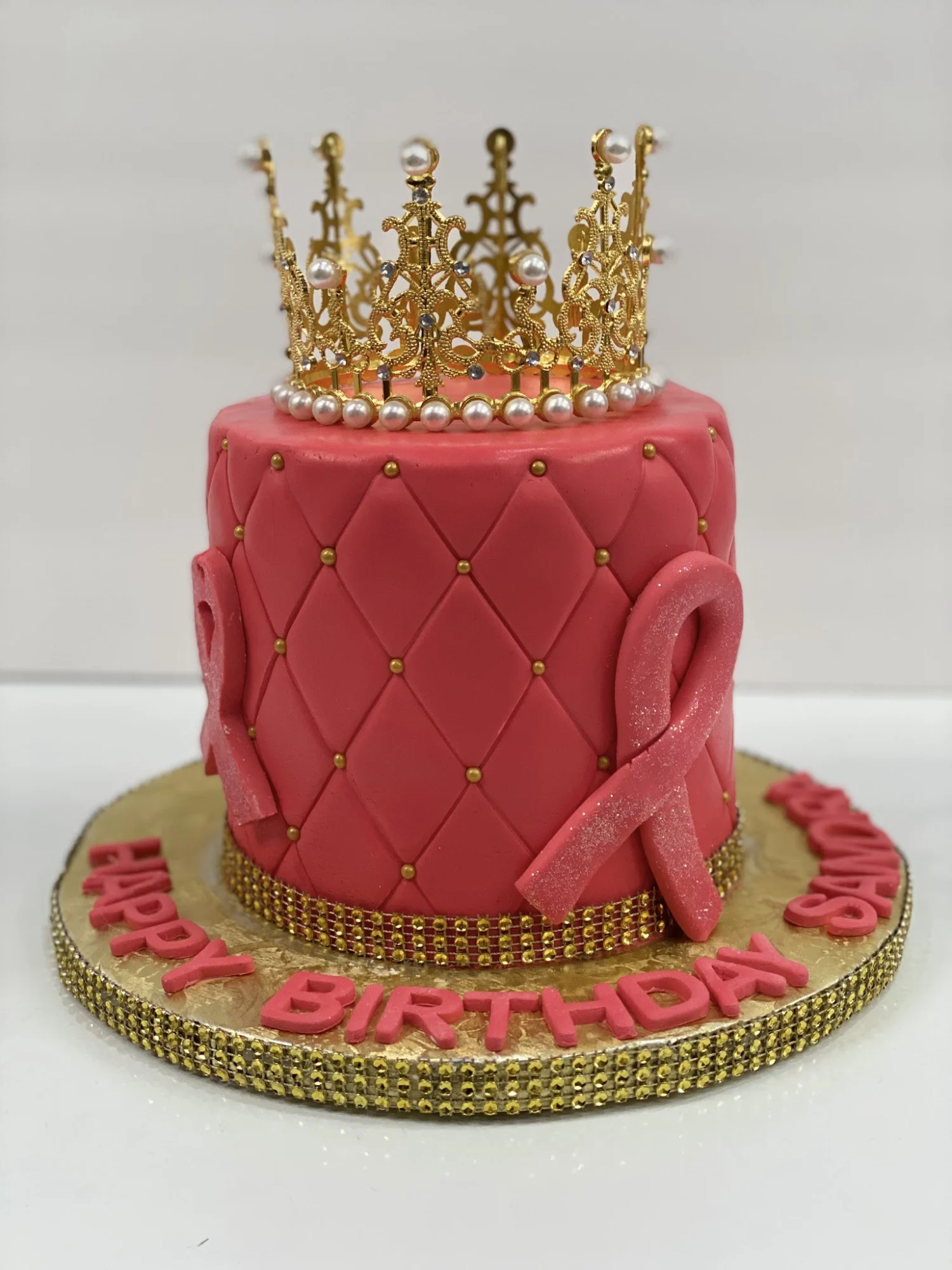 Pink cake with crown decoration and 'Happy Birthday' text at J & J Delicious Cakes, Prospect Lefferts Gardens.