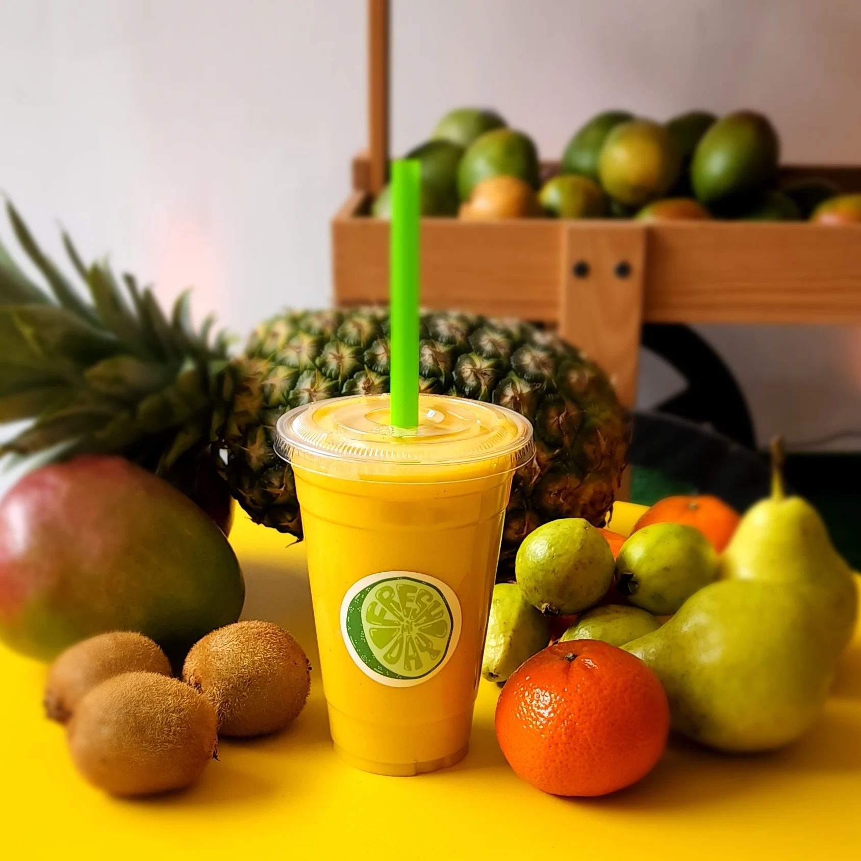 Fresh My Day featured image Yellow smoothie with green straw surrounded by tropical fruits at Fresh My Day, Greenpoint.