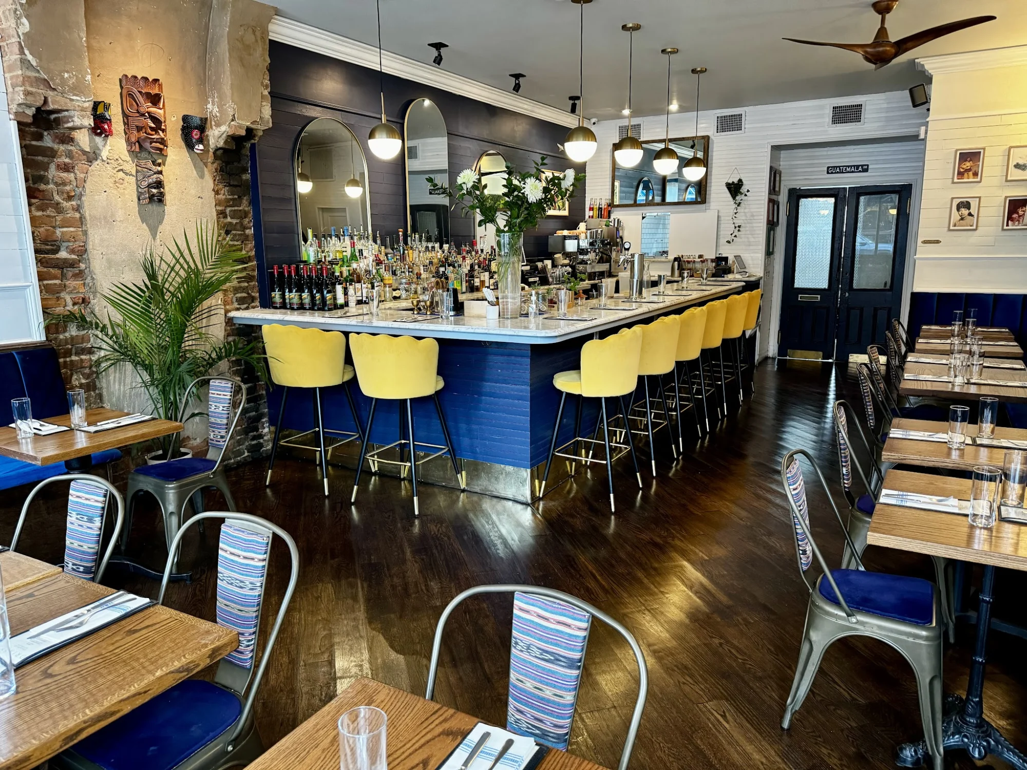 Claudia's, East Williamsburg. Bright interior with yellow bar stools around a marble top bar.