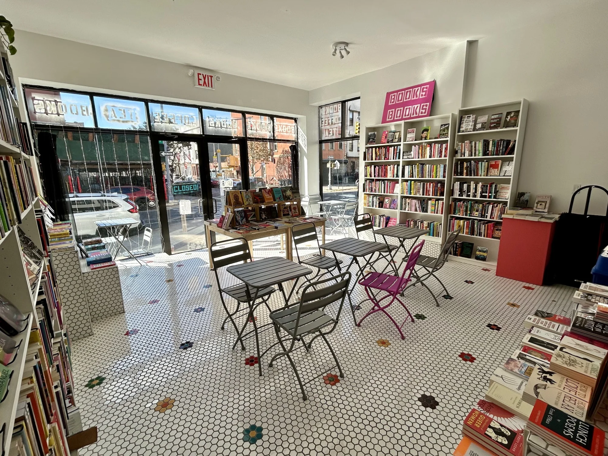Interior of Hive Mind Books & Coffee Shop, Bushwick, Bronx NYC, with tables and book shelves.