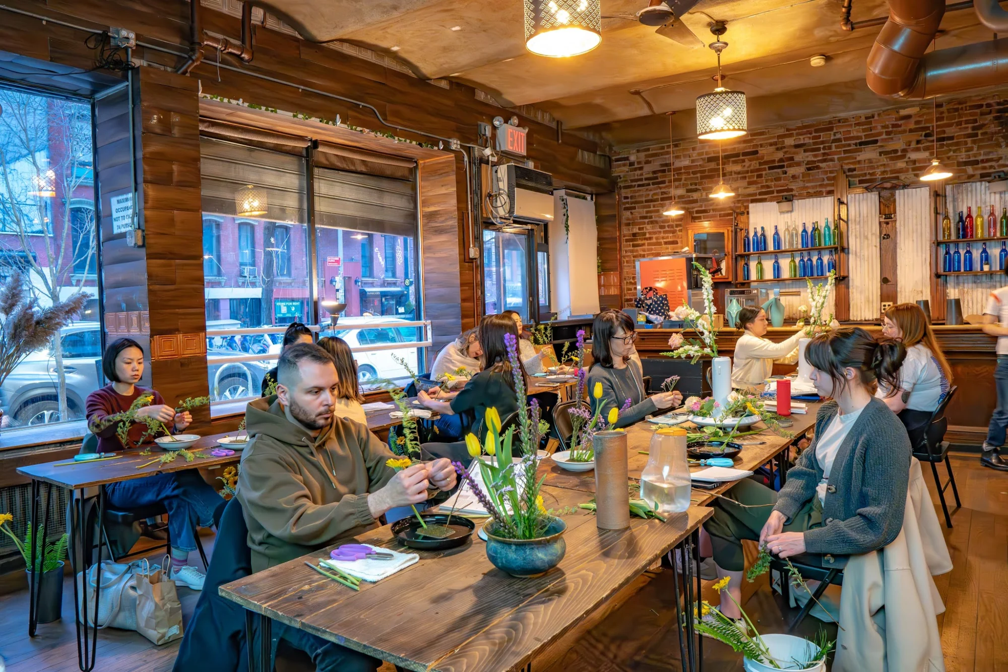 People participating in an activity inside RESOBOX East Village, filled with tables and natural light, East Village, Bronx NYC.