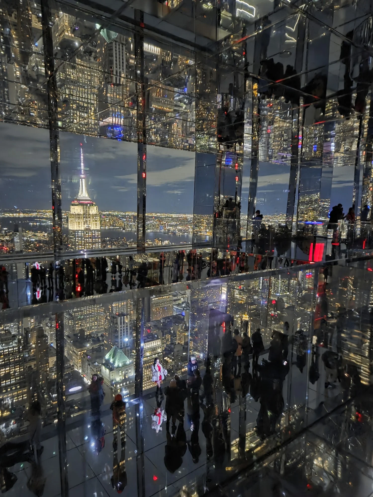 Manhattan Walking Tour featured image Reflective interior with views of cityscape, illuminated buildings and Empire State Building, Manhattan.