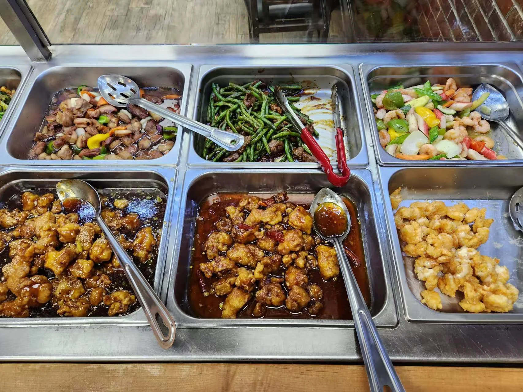 Buffet trays with various Chinese dishes including green beans, stir fry, and fried items at Chen's Brother Cuisine, Stapleton.
