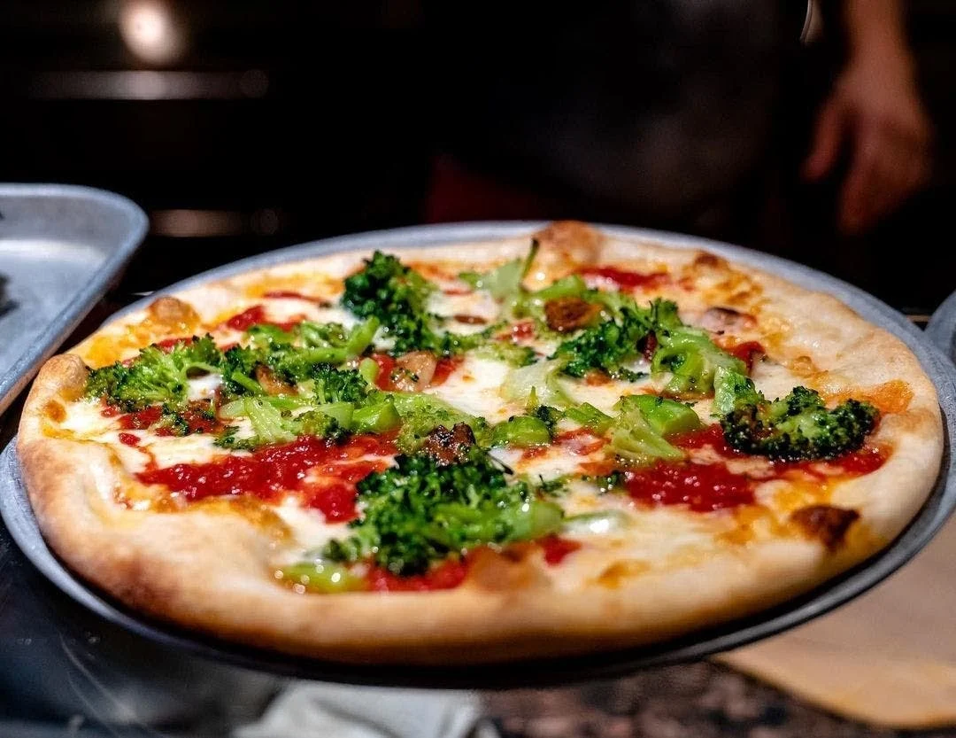 Close-up of a pizza topped with broccoli and tomato sauce at D'Angelo's Pizzeria in Parkchester.