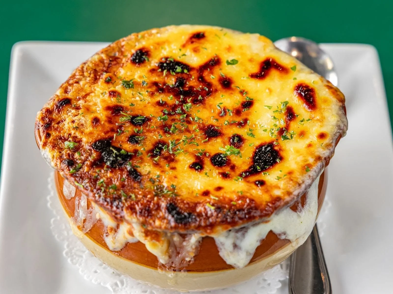 Bowl of baked cheesy dish with golden brown top at Rockwells, Bronx.