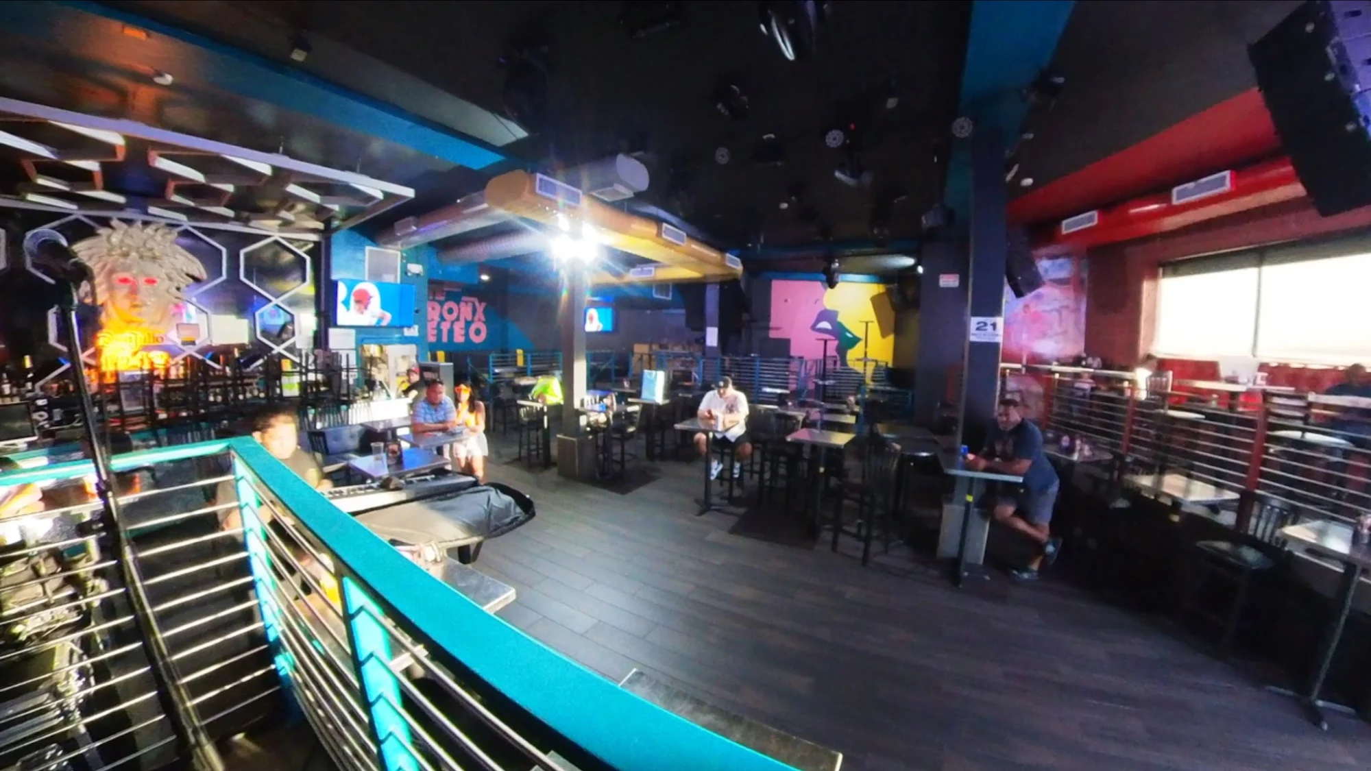 Spacious interior of Vogue Lounge in Highbridge, with colorful wall art and dim lighting.