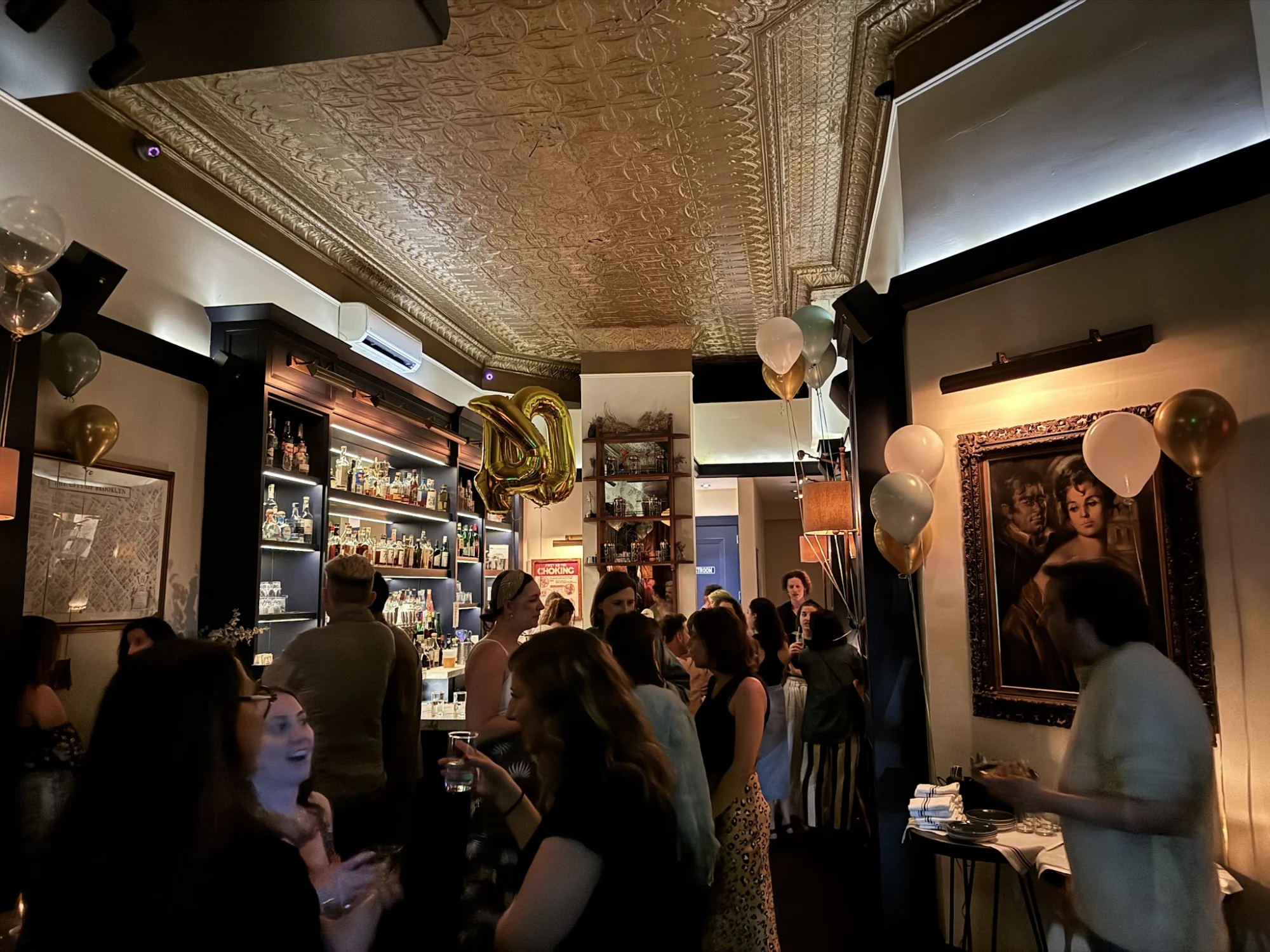 Interior of Sweet Polly, Park Slope with patrons, ornate ceiling, and bar area.