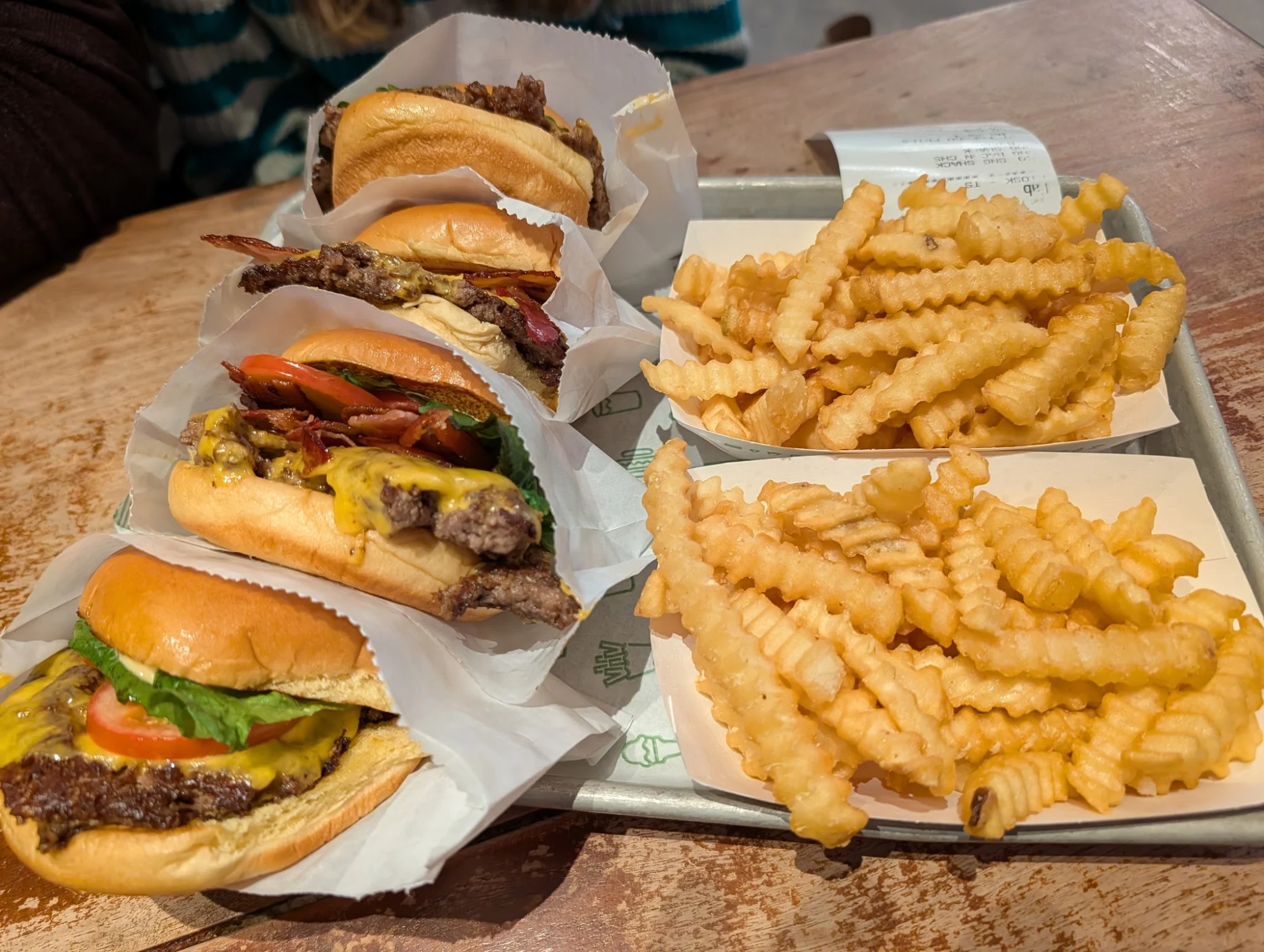 Burgers and crinkle-cut fries on a tray at Shake Shack Empire Outlets, St. George.