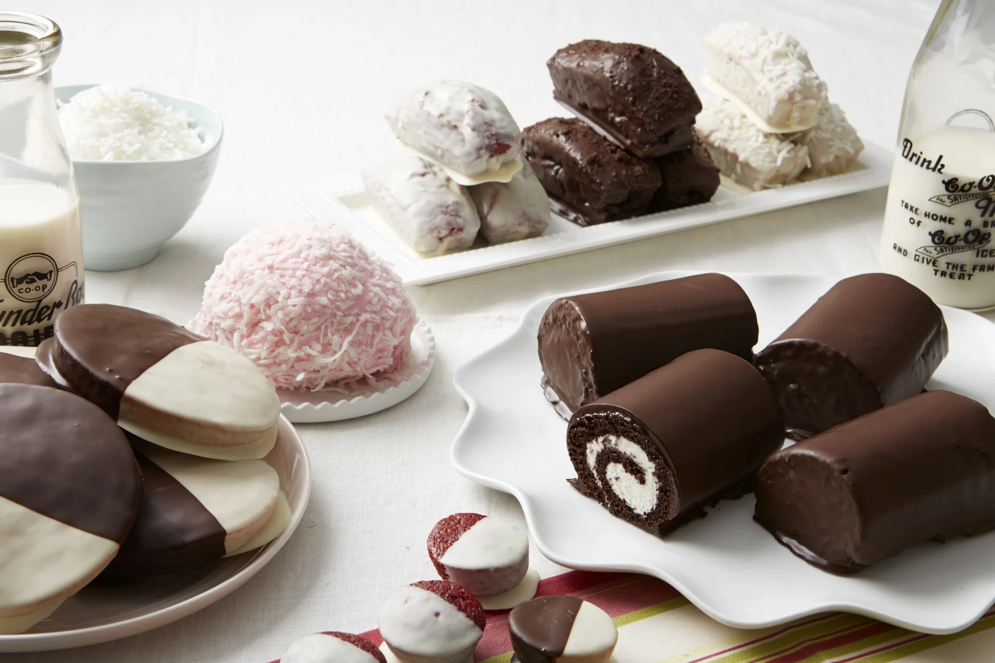 A variety of chocolate and vanilla desserts displayed on a white table at Empire Cake, Greenwich Village.