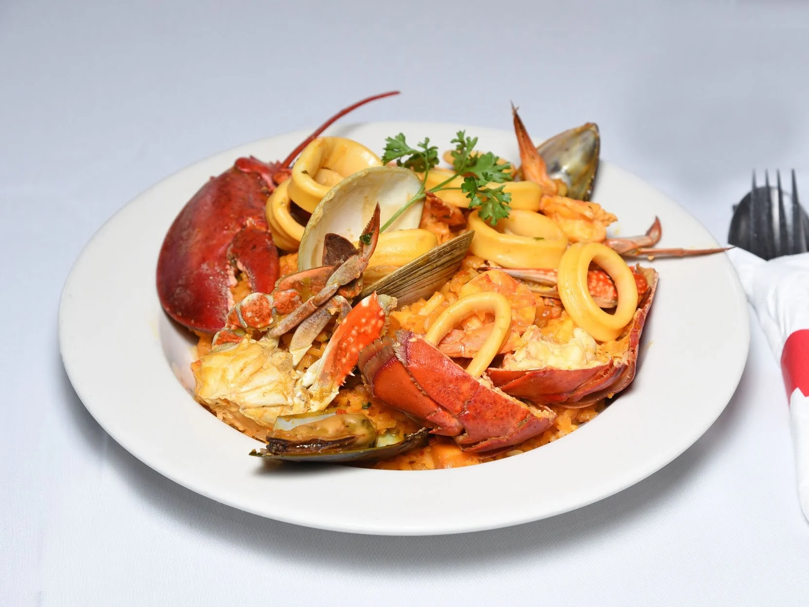 Plate of seafood pasta with lobster, clams, mussels, and calamari at Caridad & Louie's Restaurant in Baychester.