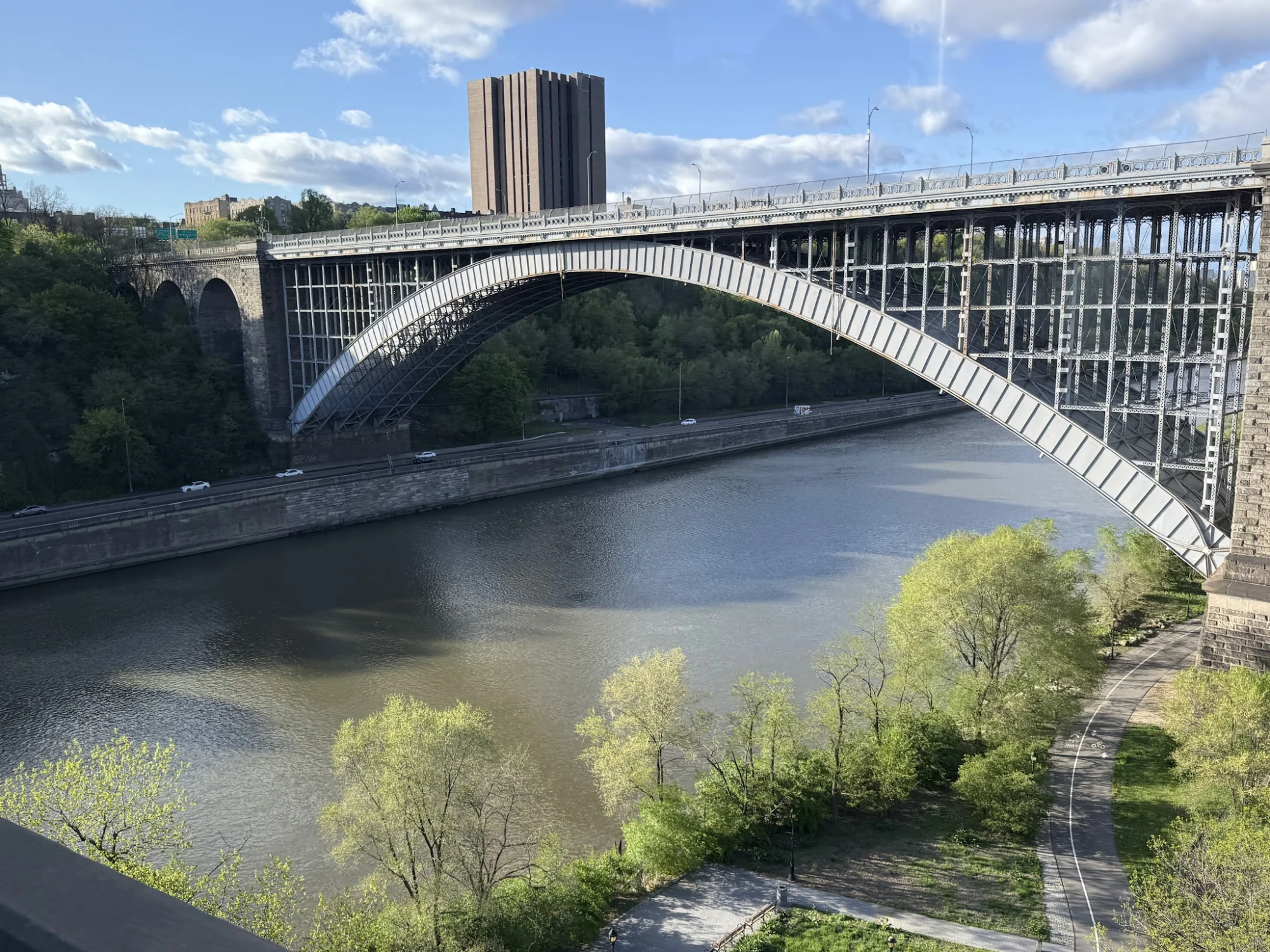 Wide view of a large arched bridge over the river at Bridge Park, Morris Heights, Bronx.