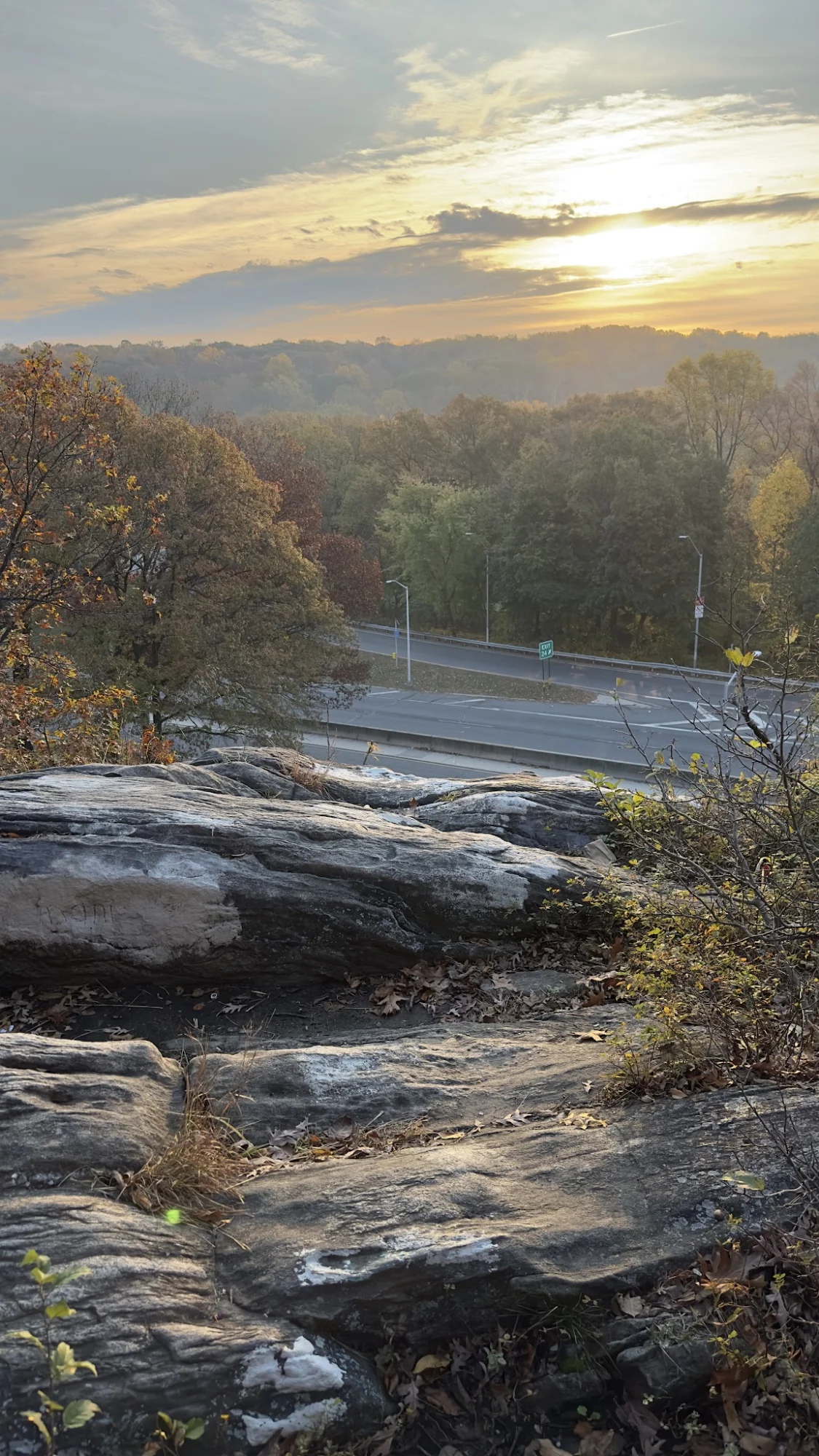 Scenic Rock Outcropping featured image Sunset view from rock outcropping overlooking road and forest in Riverdale, Bronx NYC.