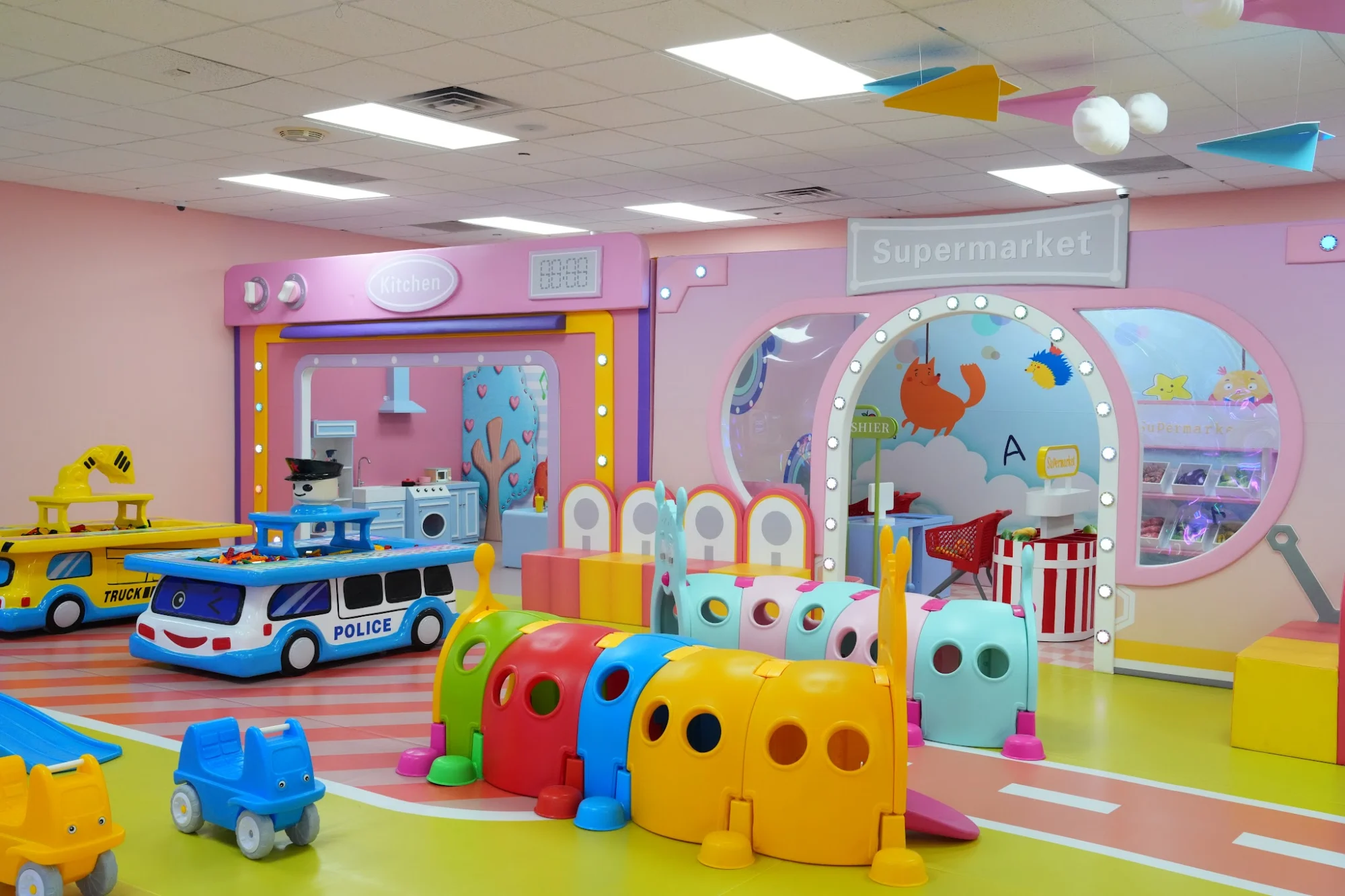 Just Kidding Playground – Universe (South Shore) featured image Colorful indoor playground with market and police car toys at Just Kidding Playground, Charleston.