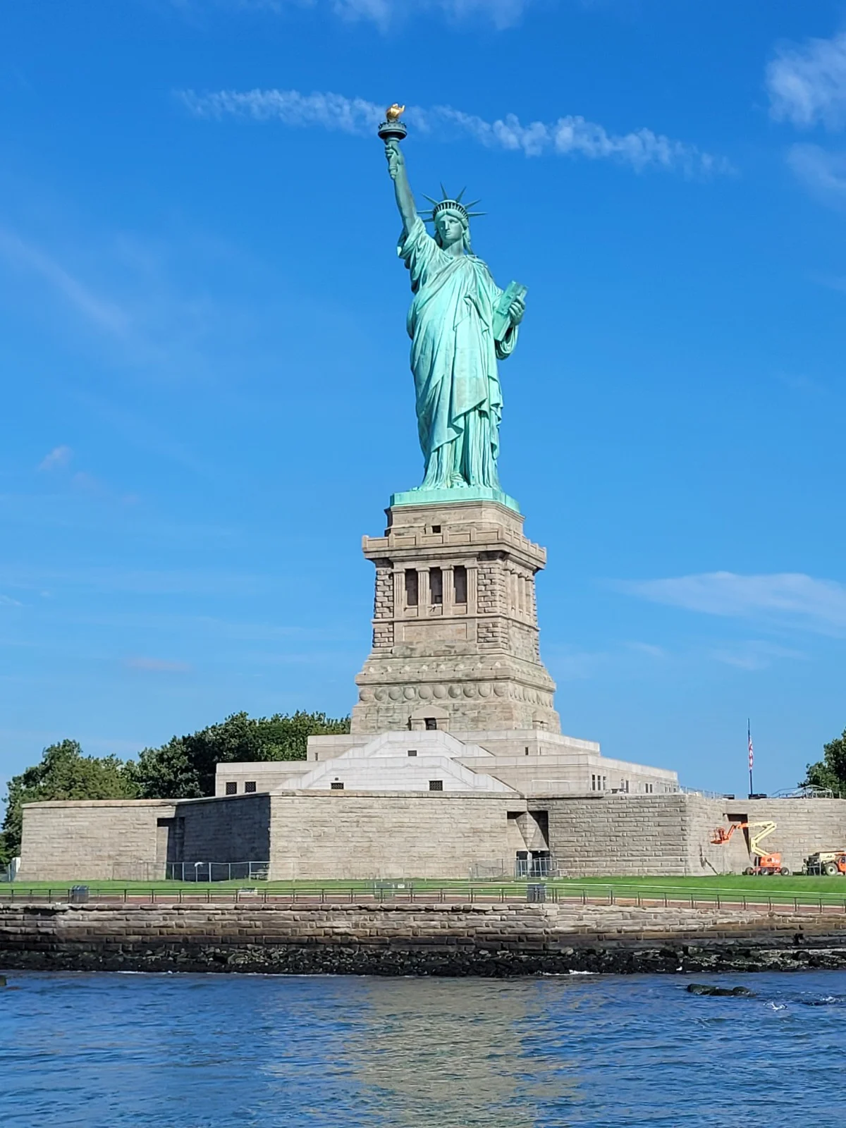 Statue of Liberty on Liberty Island under a clear blue sky.