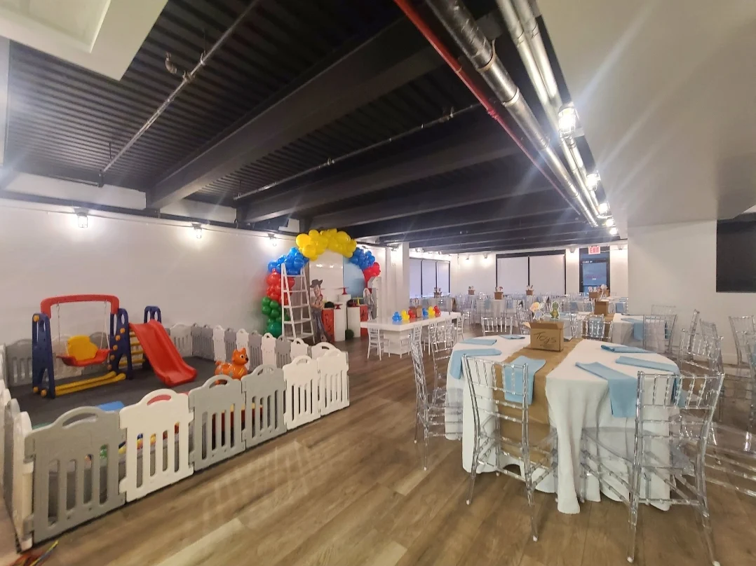 Interior with tables, chairs, and children's play area at Bella Quinn Events, Throgs Neck.