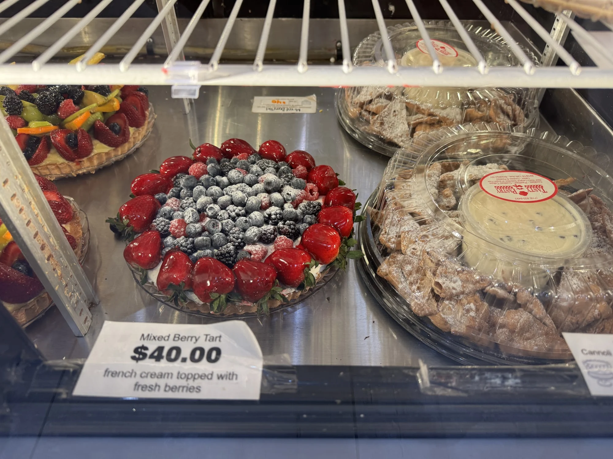 Tasty Pastry Shoppe featured image Mixed berry tart with fresh berries in a display case at Tasty Pastry Shoppe, Dyker Heights.