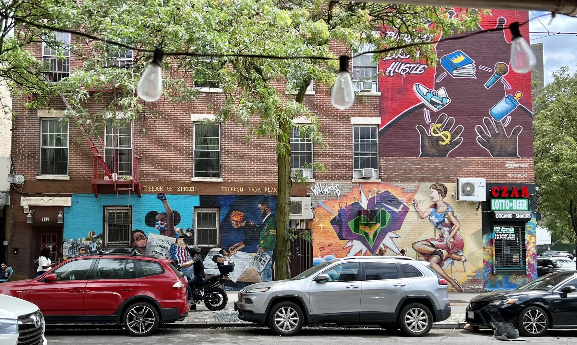 Wide shot of street murals on a building facade in Hunts Point, Bronx NYC.