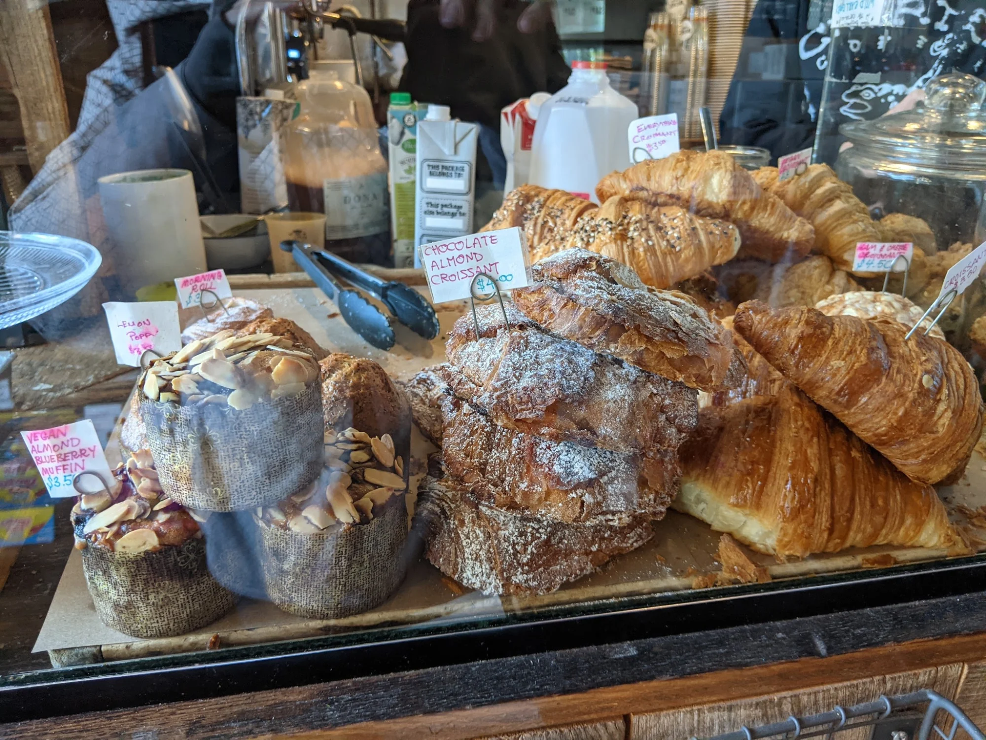 Upstate Stock featured image Display of various pastries including croissants and almond muffins at Upstate Stock, Williamsburg.