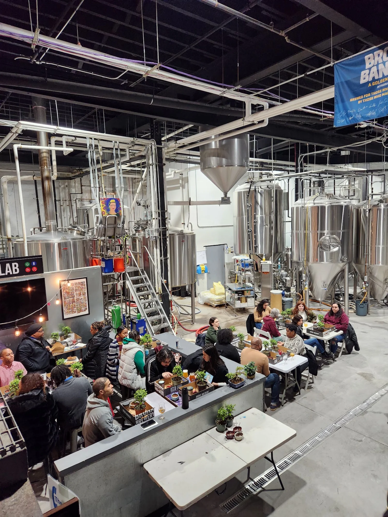 Interior of Bronx Brewery with large tanks and people seated at tables, Port Morris.