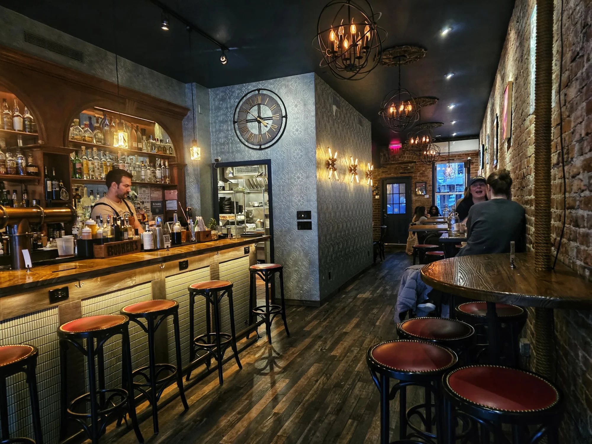 Bar Dalia featured image Interior of Bar Dalia in Astoria, featuring a well-lit bar with stools, patrons, and cozy decor.