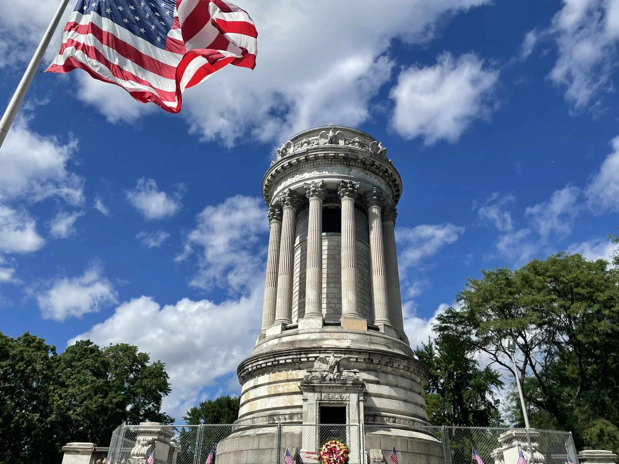 Soldier Monument in Randall Manor, Bronx with American flag and blue sky in the background.