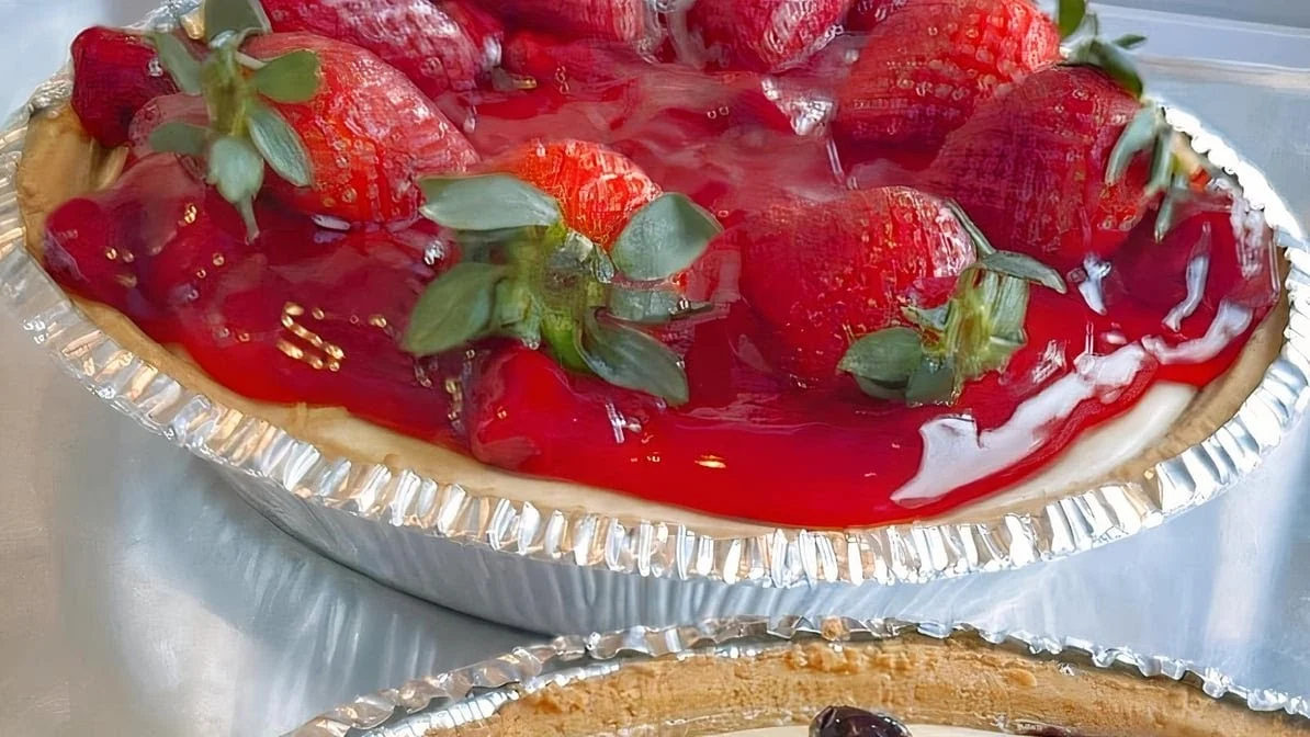 Yummy Tummy’s Kitchen featured image Close-up of a pie with fresh strawberries and red glaze in a foil tray at Yummy Tummy’s Kitchen, Williamsburg.