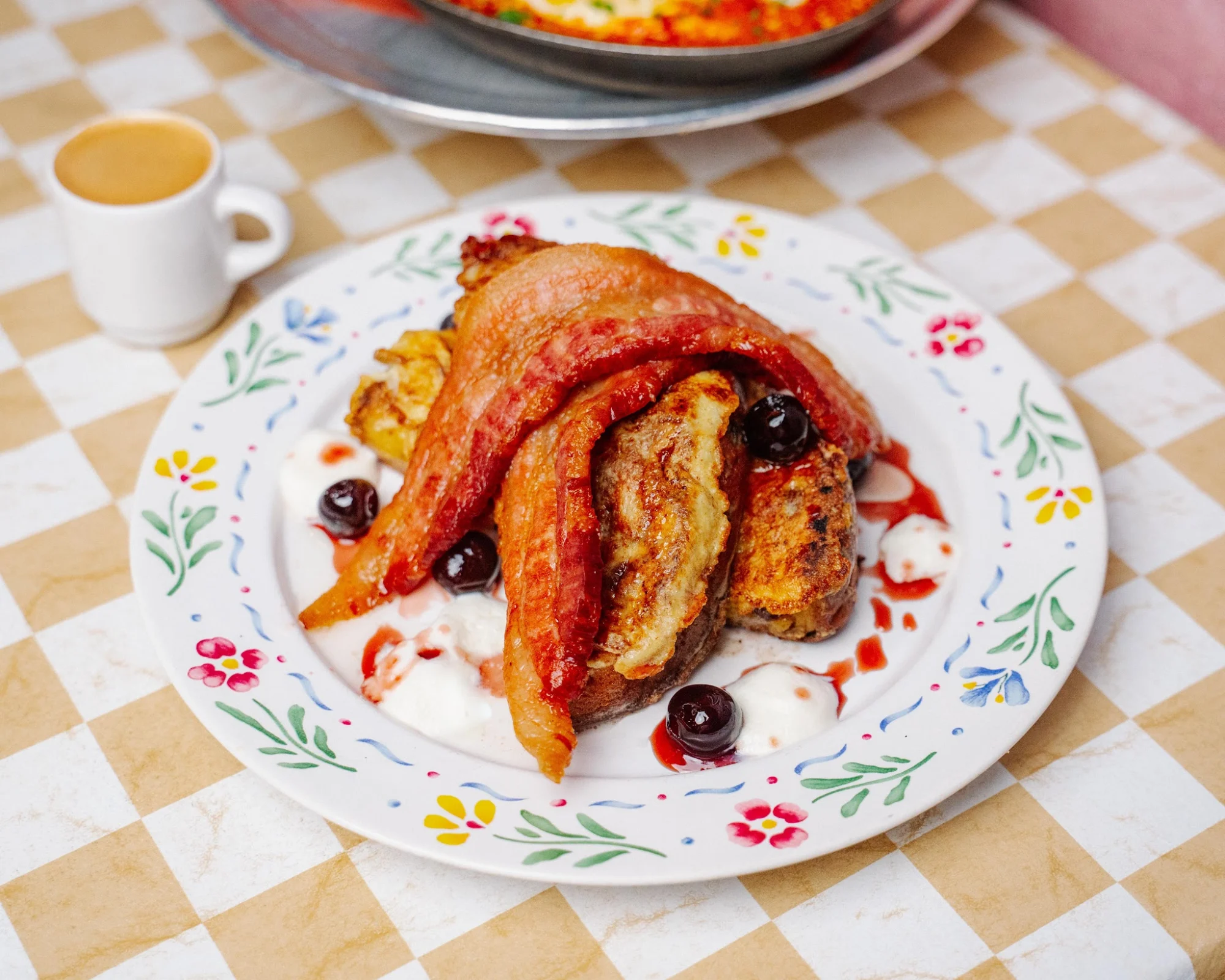 Kingsbridge Social Club featured image Plate of food with bacon, pancakes, cherries, and cream at Kingsbridge Social Club, Kingsbridge Bronx.