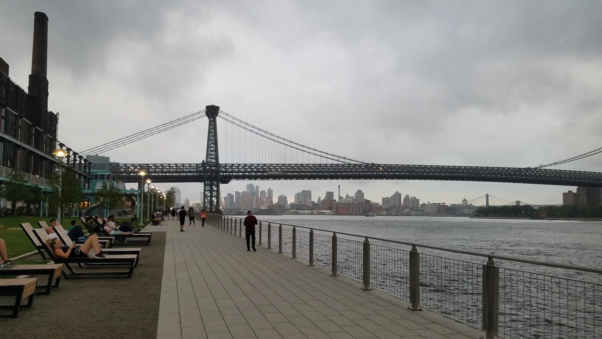 Grand Ferry Park featured image View of the waterfront promenade at Grand Ferry Park, Williamsburg, with the Williamsburg Bridge and city skyline in the background.