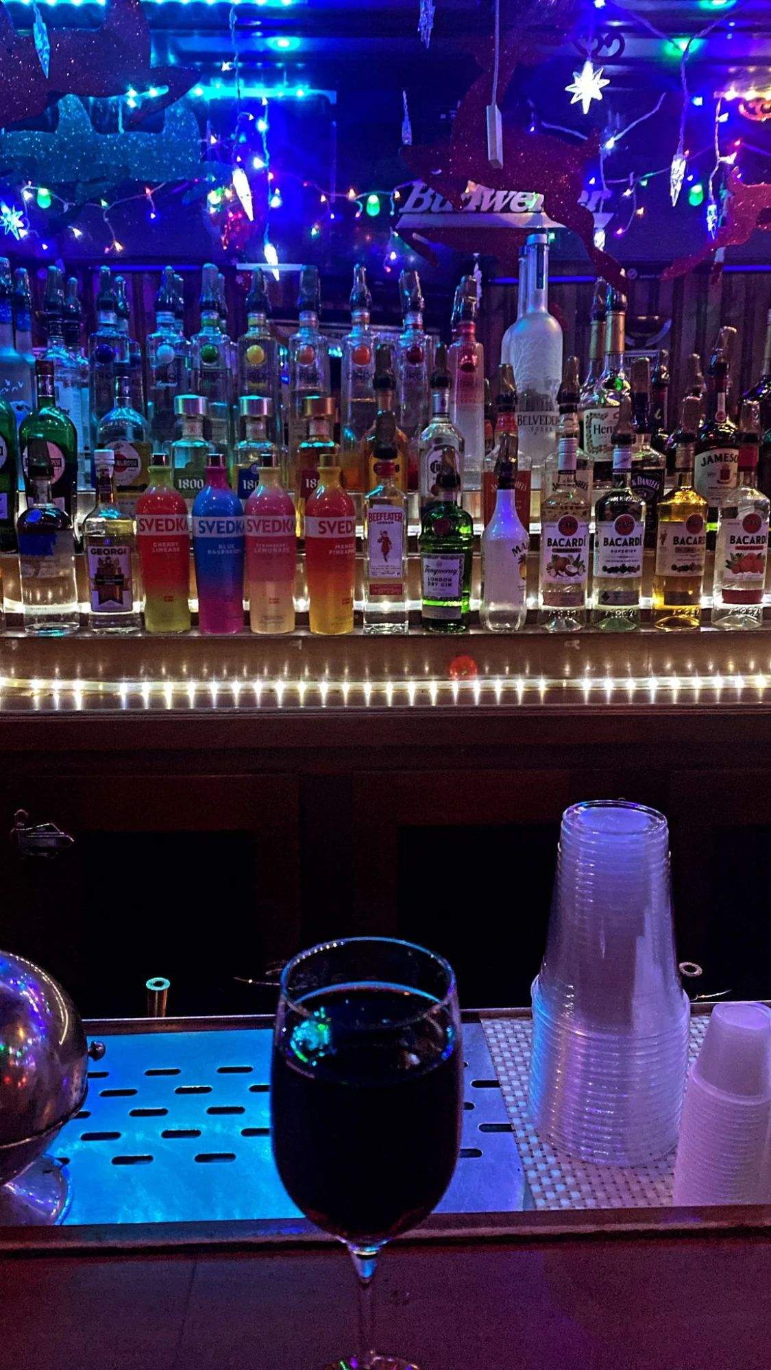 PreGame Sports Bar & Lounge featured image Fully stocked bar with colorful bottles and LED lights, PreGame Sports Bar & Lounge, Jamaica, Bronx NYC.