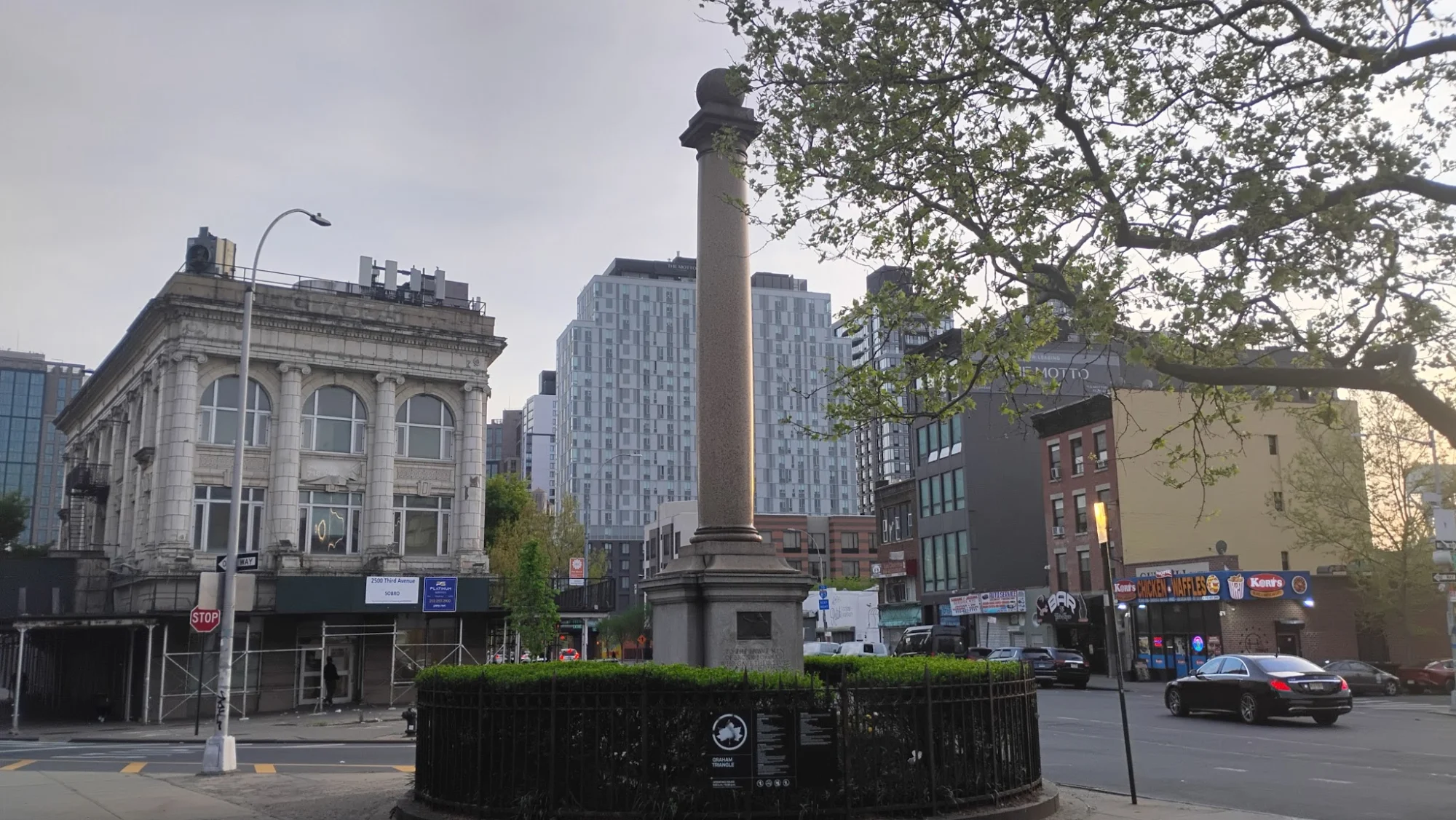 Graham Triangle featured image Graham Triangle monument with tall pillar in Mott Haven, Bronx, surrounded by buildings.
