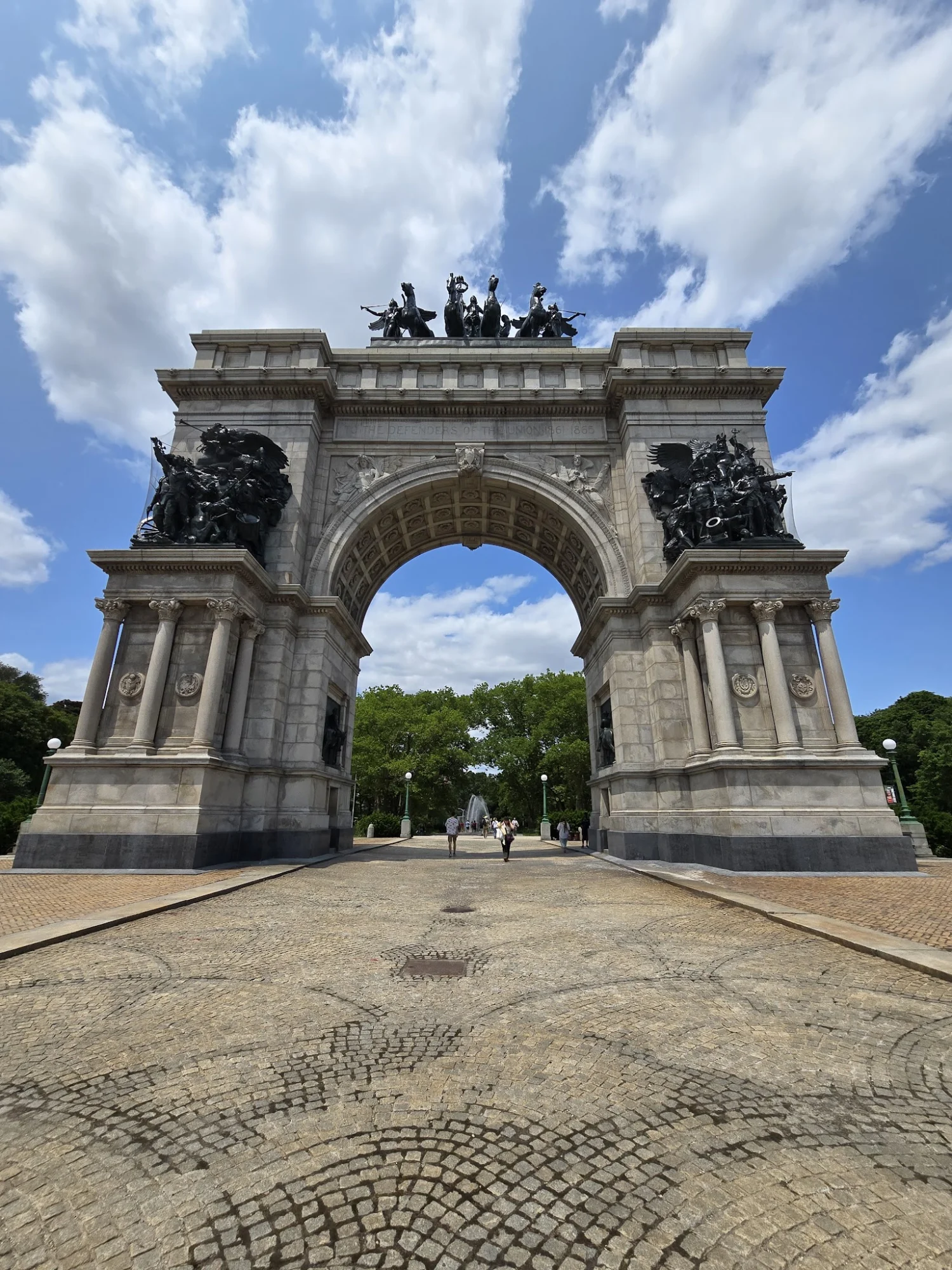 Large arch structure with sculptures and a cobblestone path in Prospect Heights, Bronx NYC.