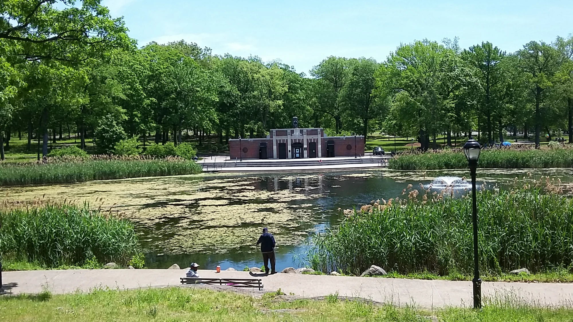 View of Crotona Park with a lake and a building in the background, Bronx NYC.