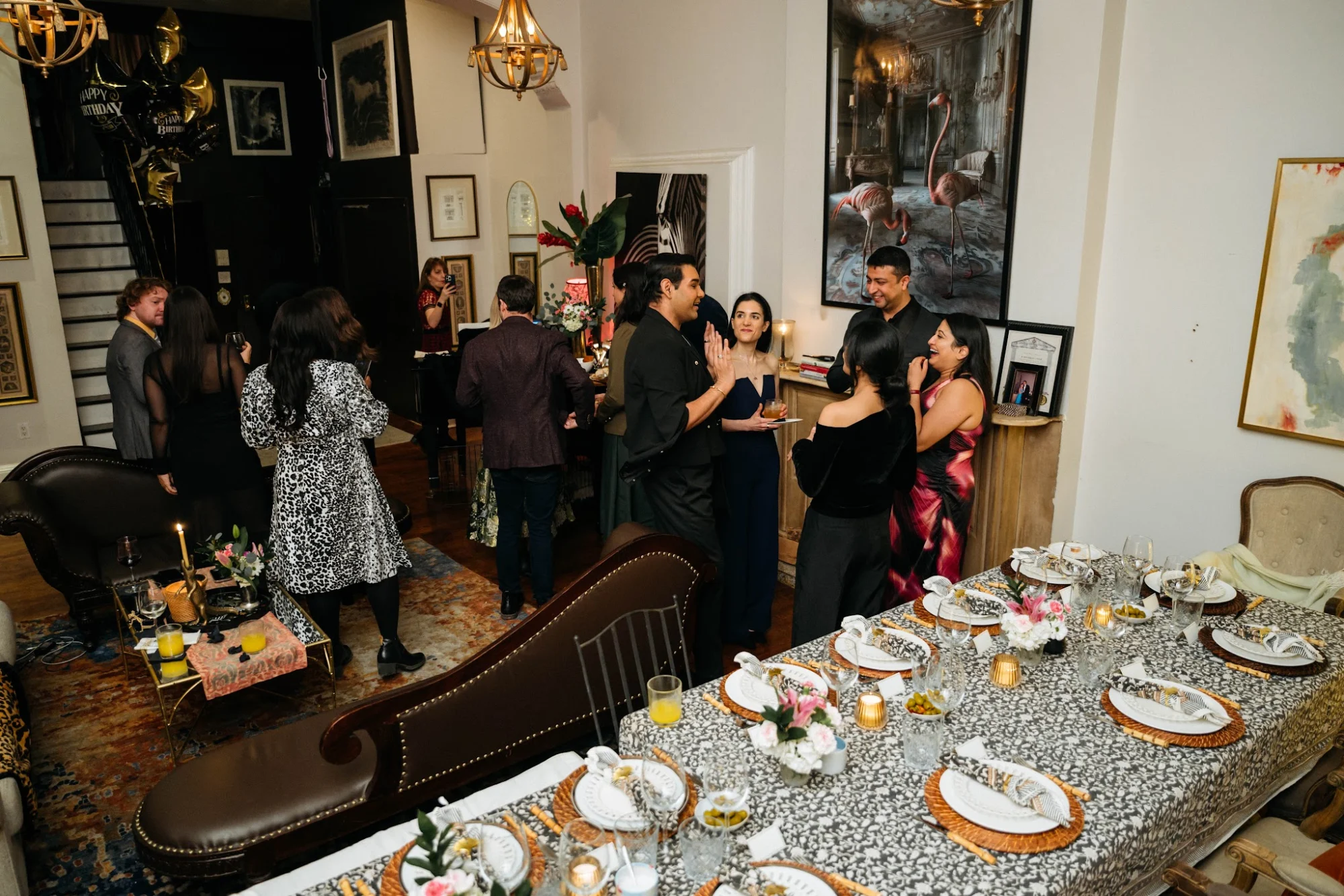Interior of Supper Club NYC in Flatiron District with a gathering of people around a set dining table.