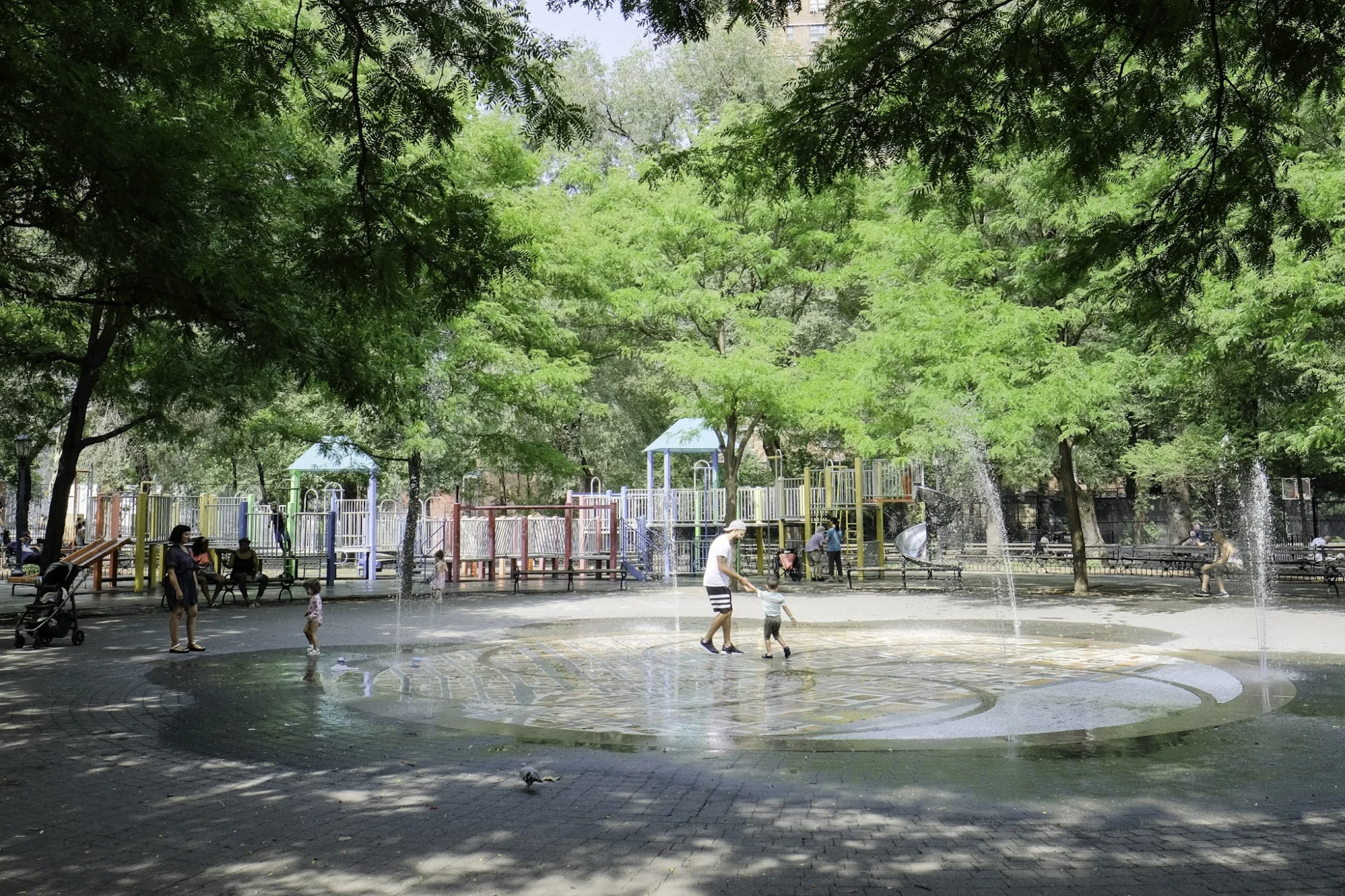 Seward Park featured image Children playing in a water feature surrounded by trees in Seward Park, Lower East Side.