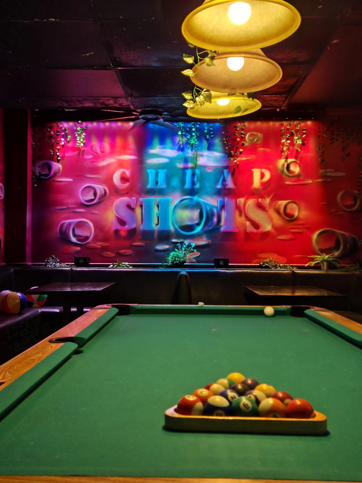 Pool table with colorful lights and Cheap Shots decor in Kew Gardens Hills.