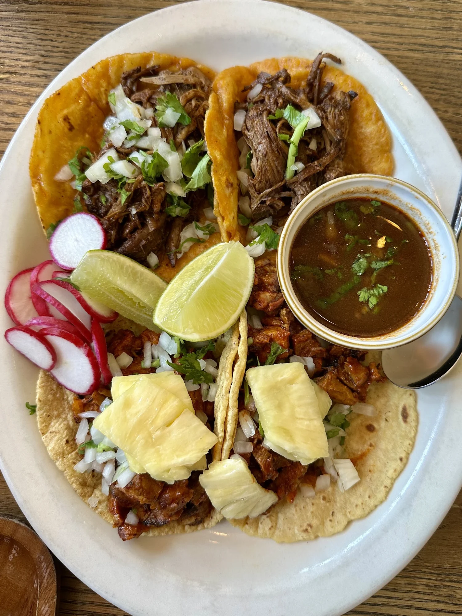 Oso featured image Plate with tacos, lime wedges, radishes, pineapple slices, and a small bowl of sauce at Oso, Hamilton Heights.