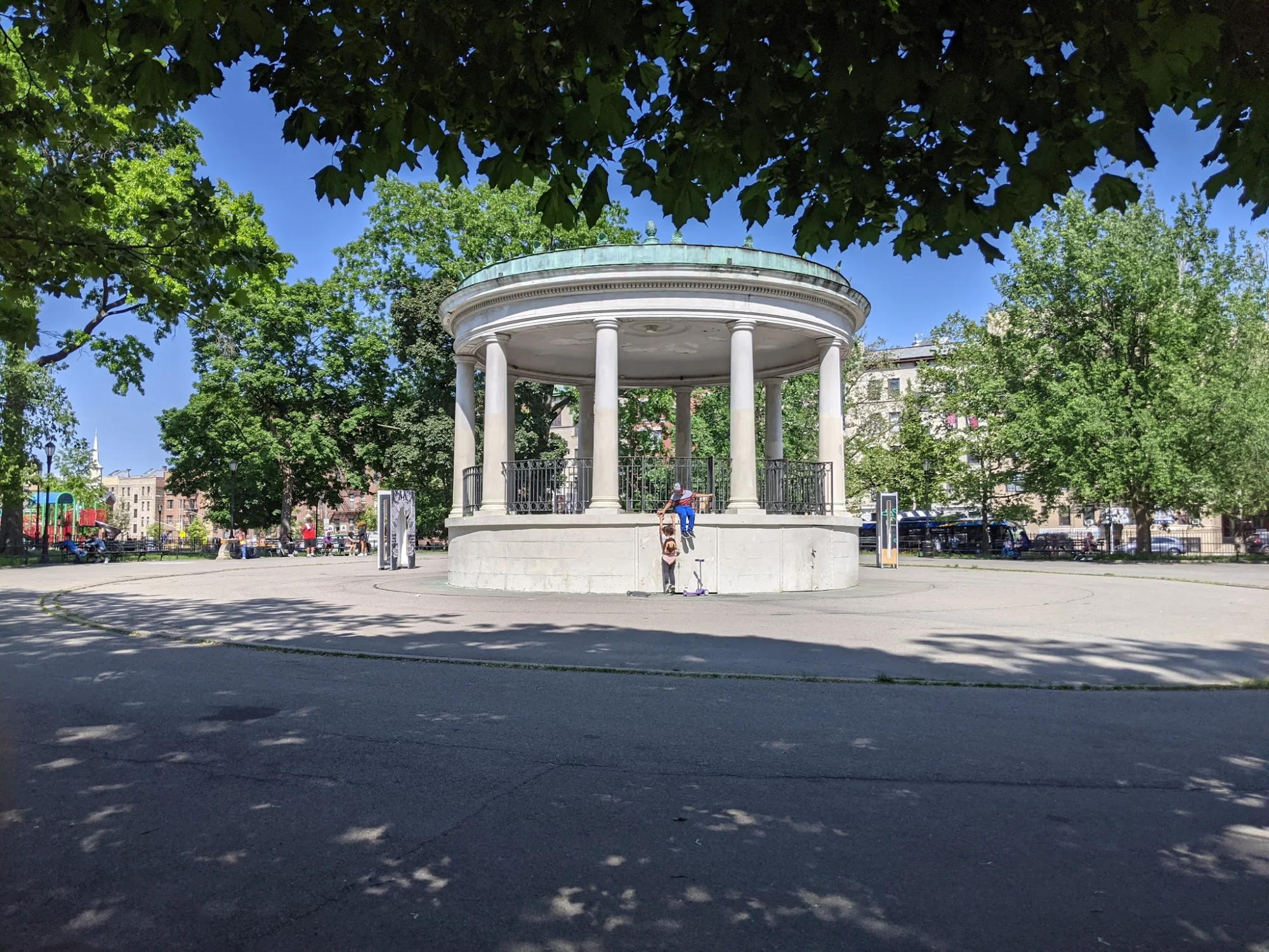 Gazebo structure in Poe Park, surrounded by trees and open space in Fordham, Bronx.