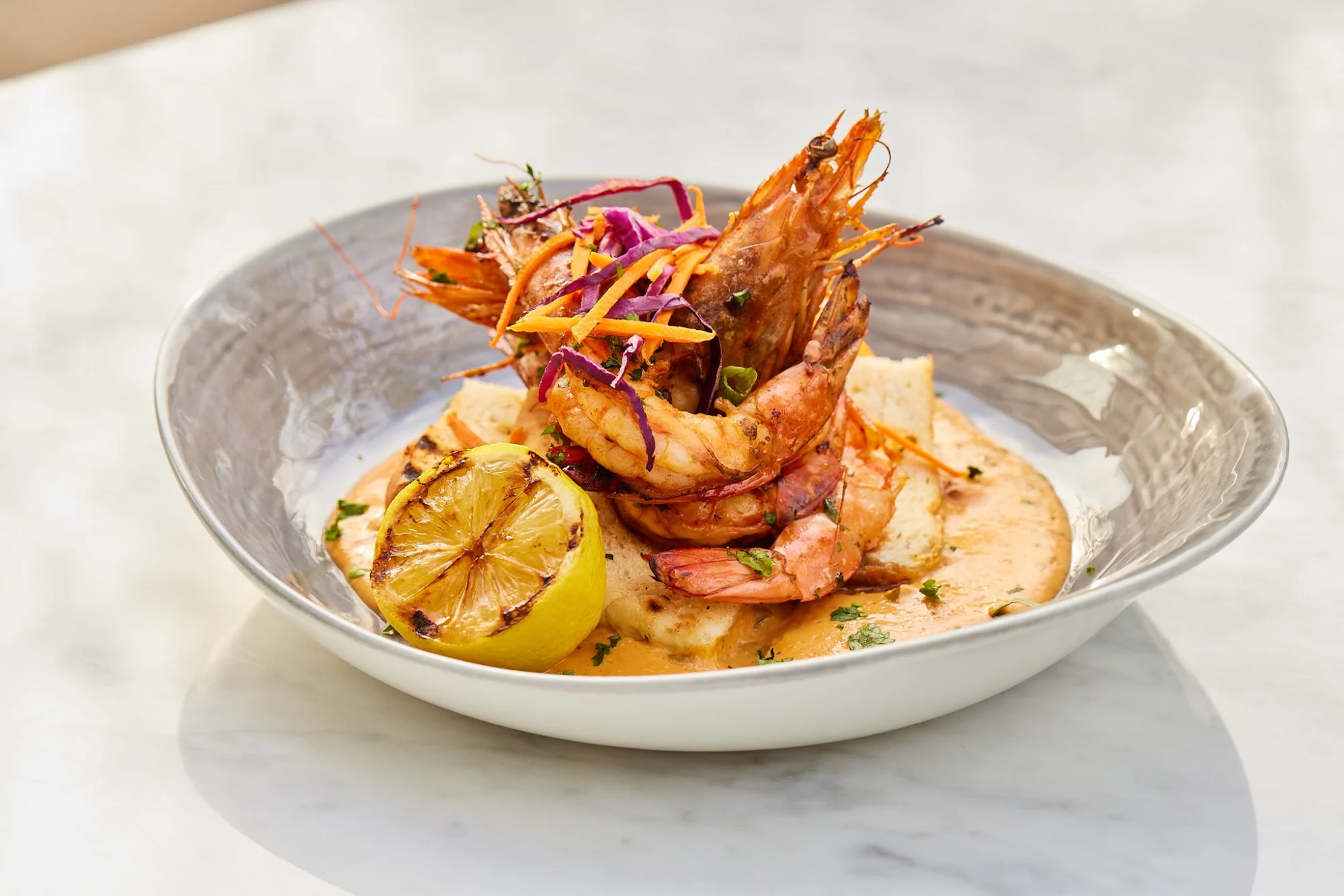 Grilled shrimp on toast with sauce and a grilled lemon at Continent Brooklyn, Williamsburg.