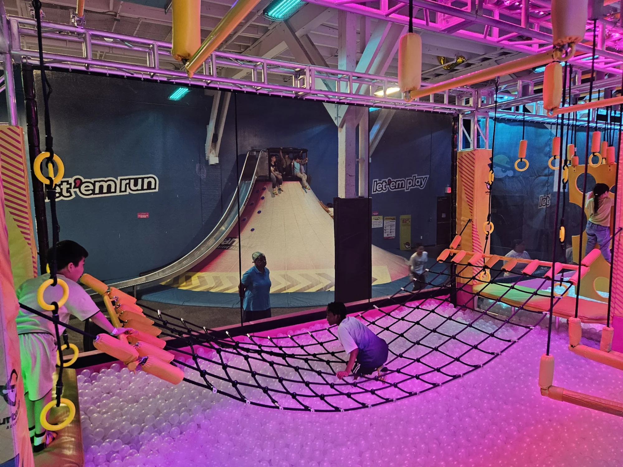 Urban Air Trampoline and Adventure Park featured image Obstacle course with netting and climbing elements at Urban Air Trampoline and Adventure Park, Sunset Park, Bronx NYC.