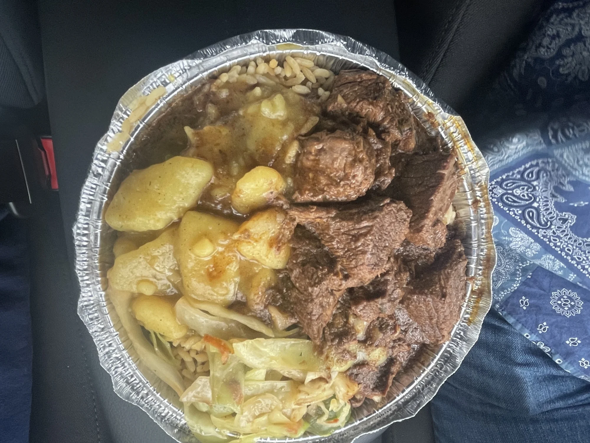 Close-up of a takeout container with meat, vegetables, and potatoes at Feroza's, Williamsbridge Bronx NYC.