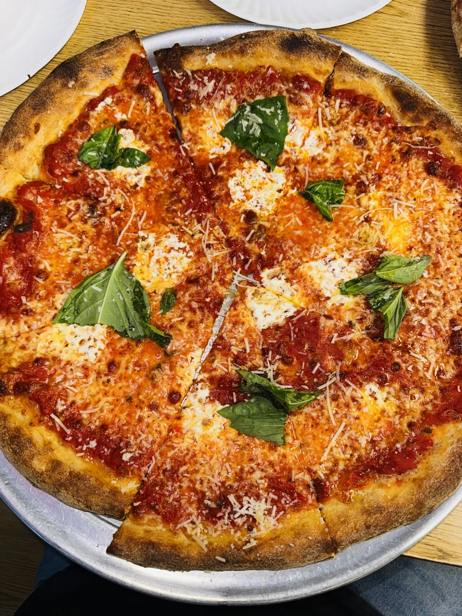 Margherita pizza with basil on a metal tray at Pizza Fenice.